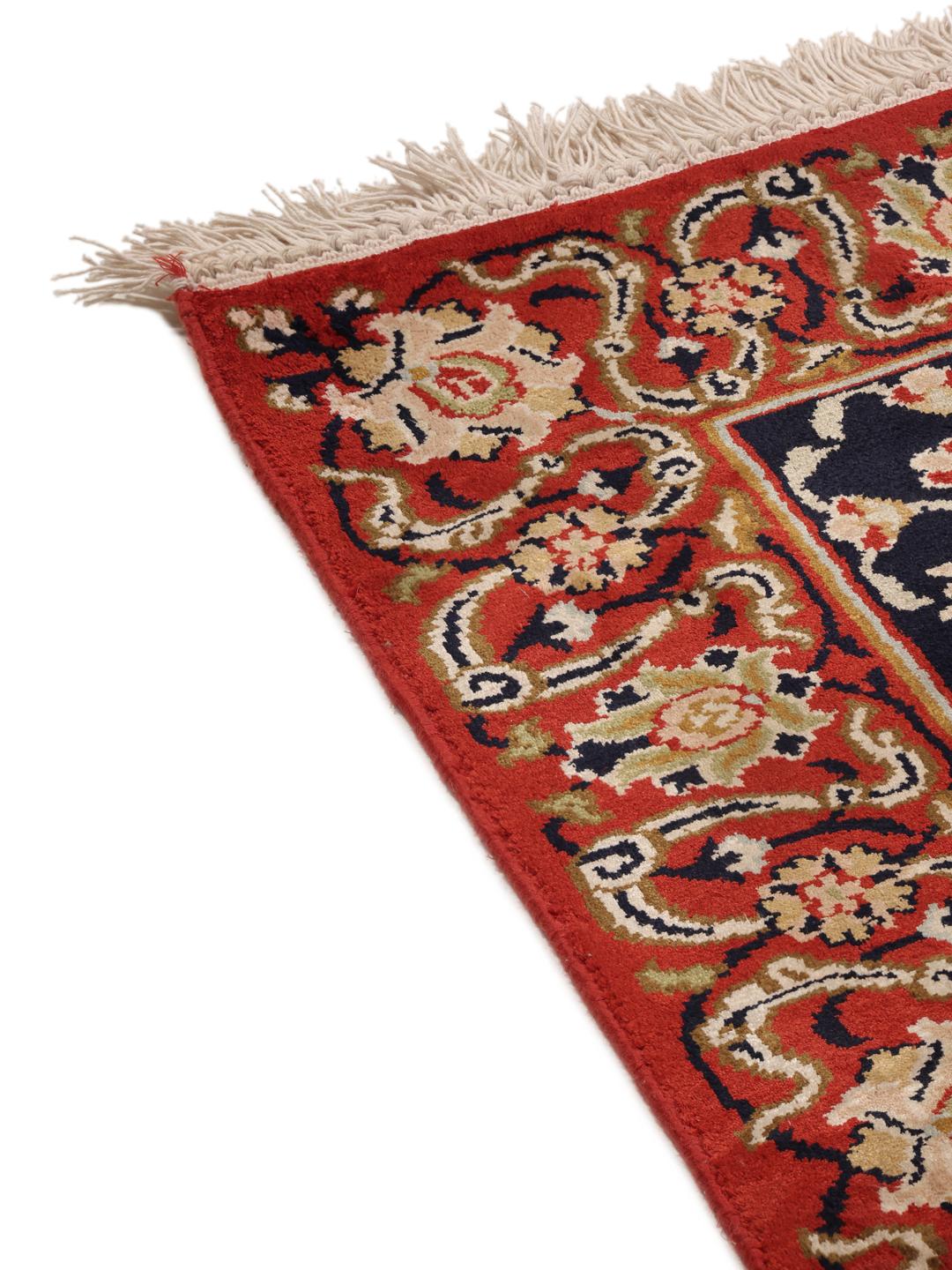 Een groot rechthoekig Kashmir zijden tapijt uit India met een levendig rood veld en gedetailleerde bloempatronen.