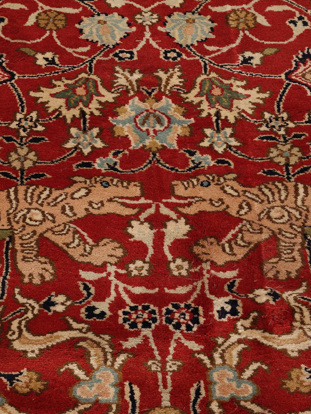Een groot rechthoekig Kashmir zijden tapijt uit India met een levendig rood veld en gedetailleerde bloempatronen.