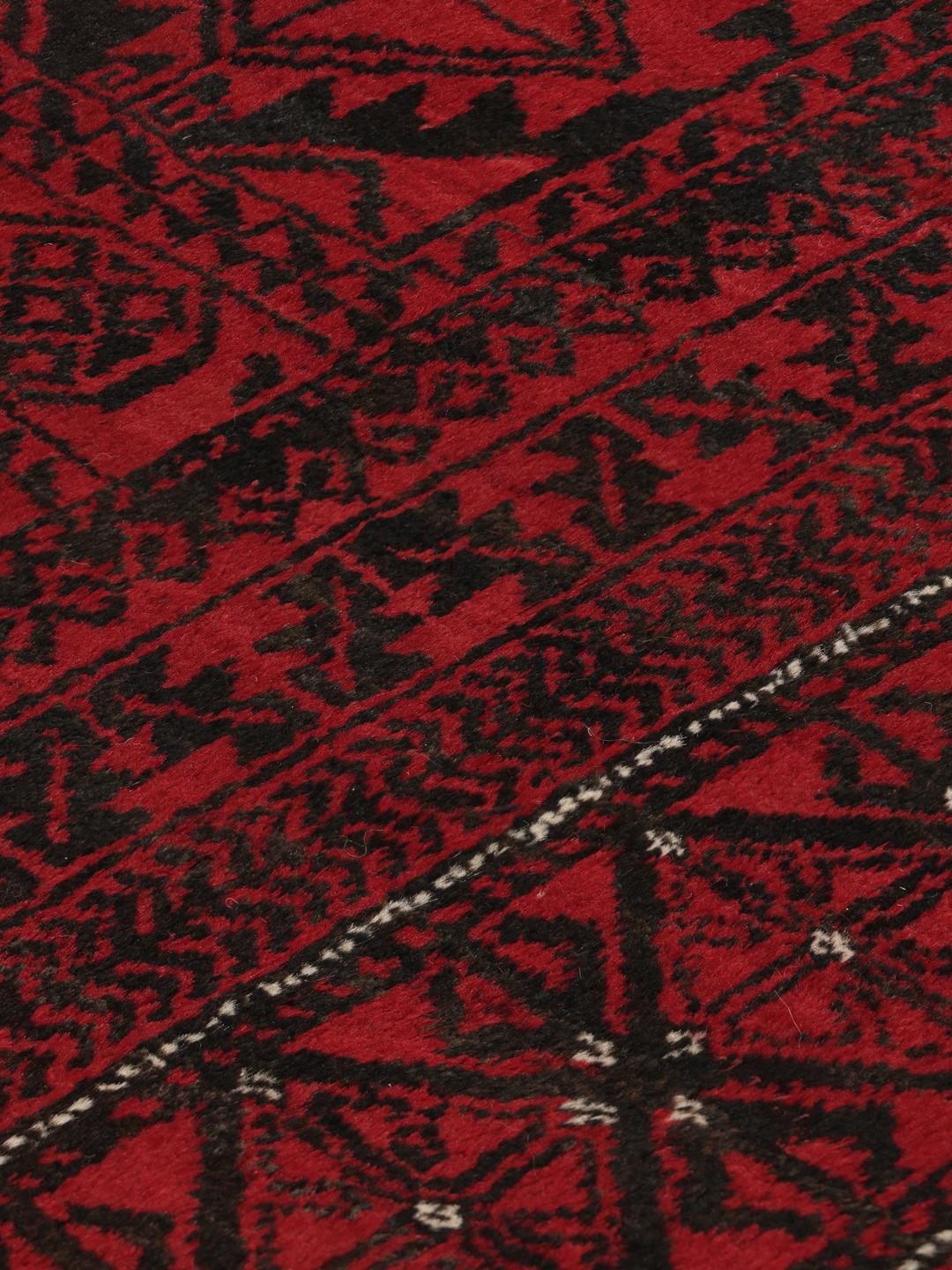 Håndknyttet afghansk tæppe med traditionelle mørkerøde og sorte geometriske mønstre