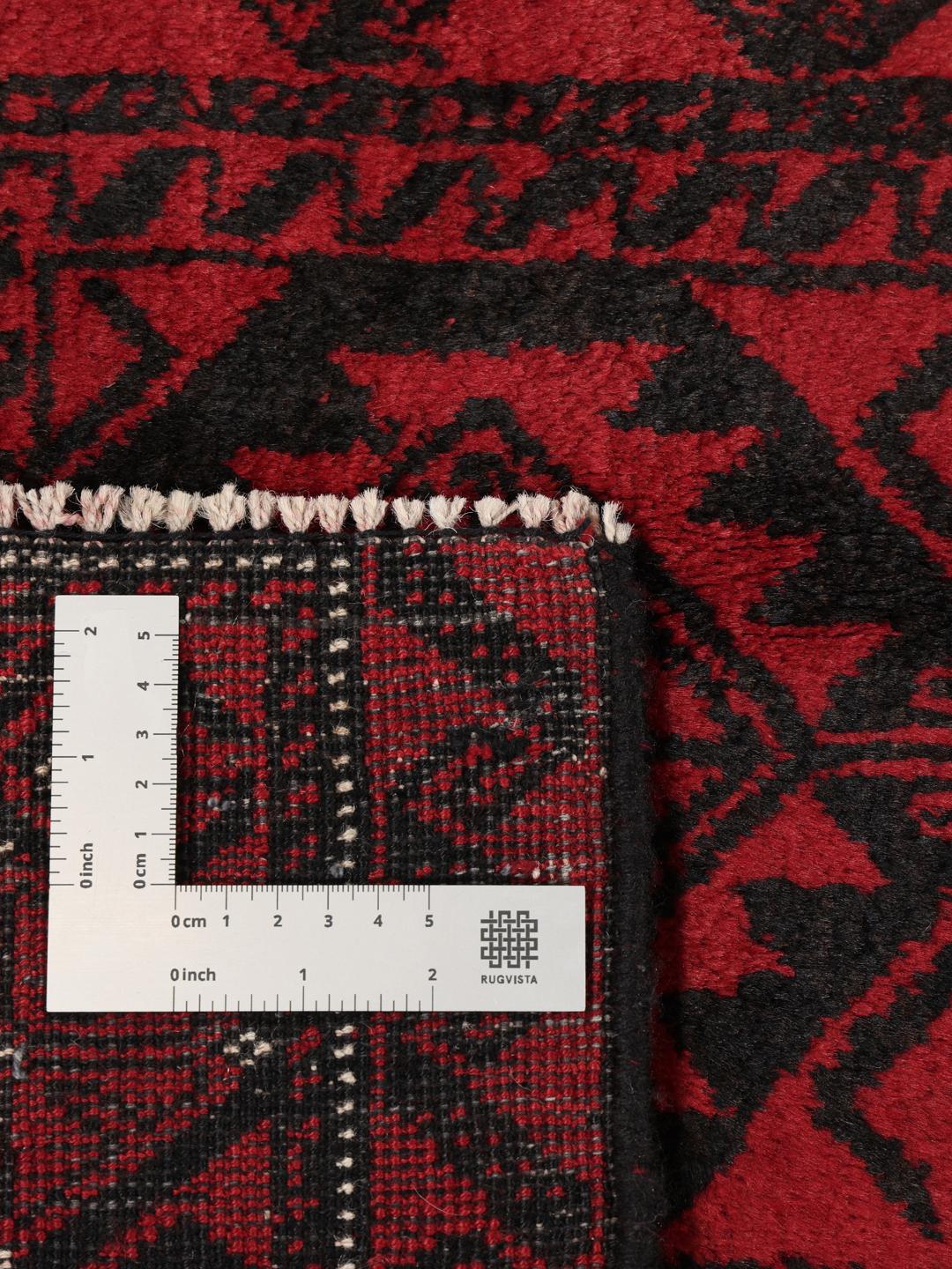 Håndknyttet afghansk tæppe med traditionelle mørkerøde og sorte geometriske mønstre