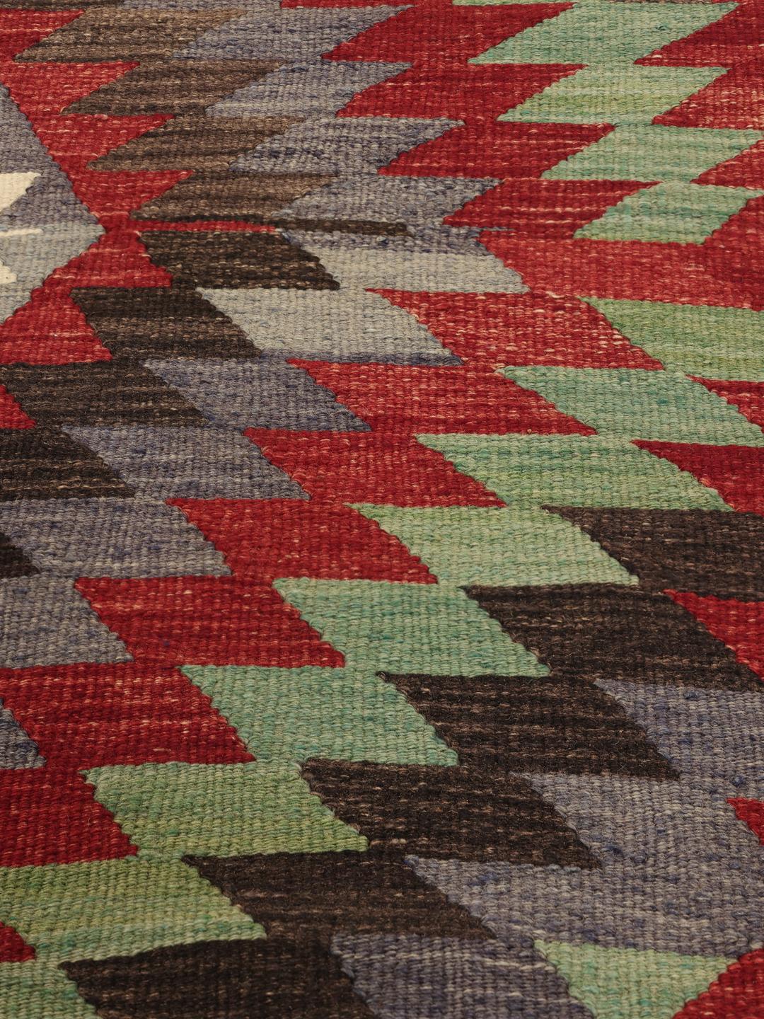 Handgeweven Turks kelimkleed met levendige geometrische patronen in rood, groen en grijs