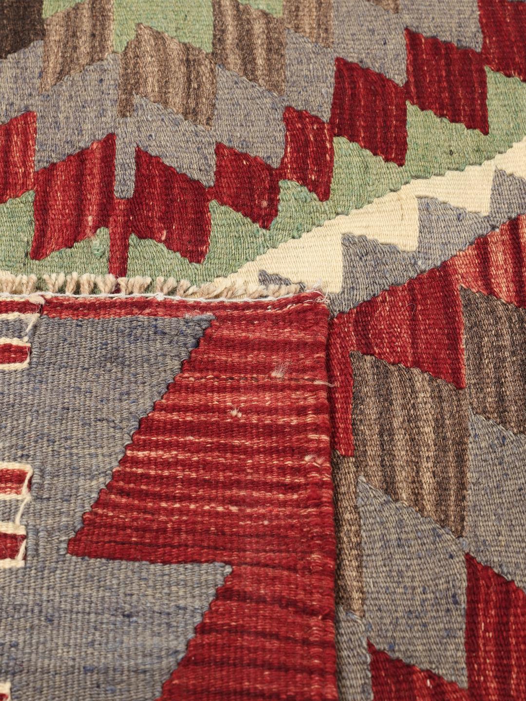 Handgeweven Turks kelimkleed met levendige geometrische patronen in rood, groen en grijs