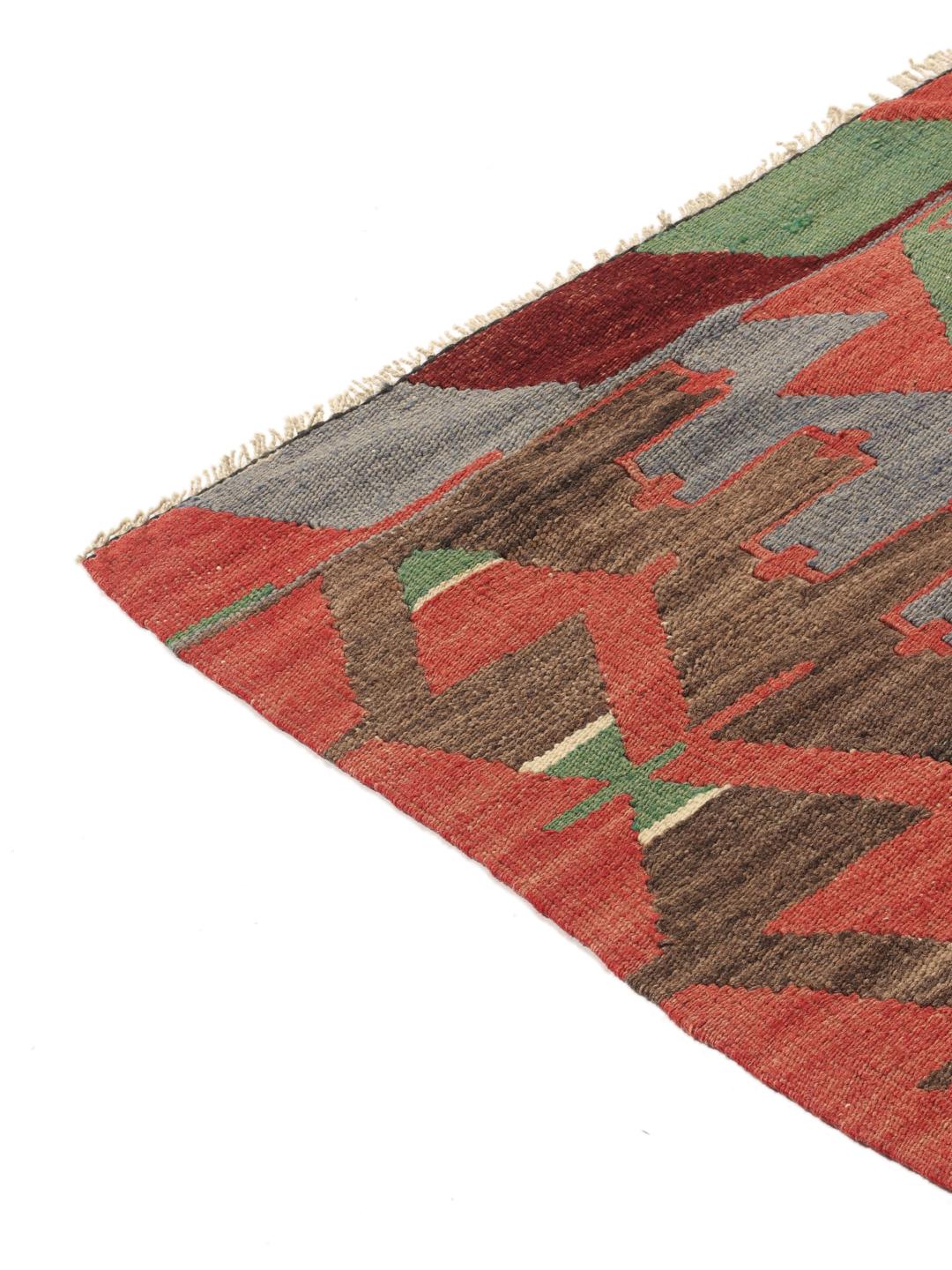 Un tapis Kelim turc vintage présentant un motif géométrique en laine multicolore.