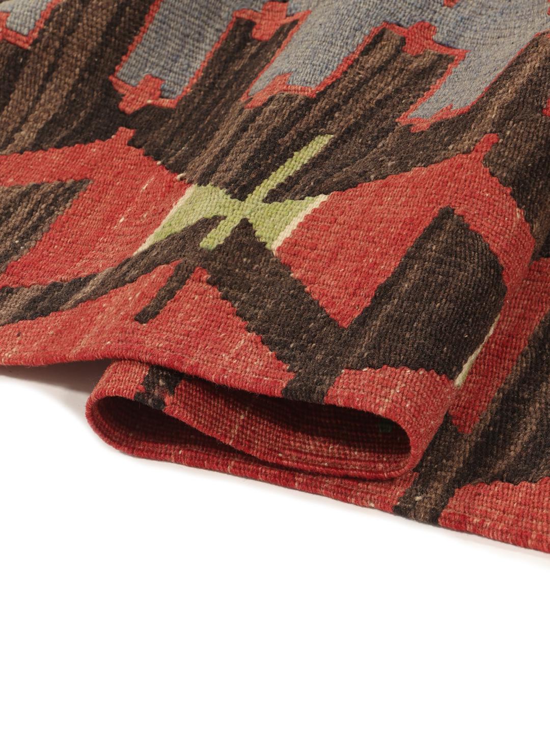 Un tapis Kelim turc vintage présentant un motif géométrique en laine multicolore.