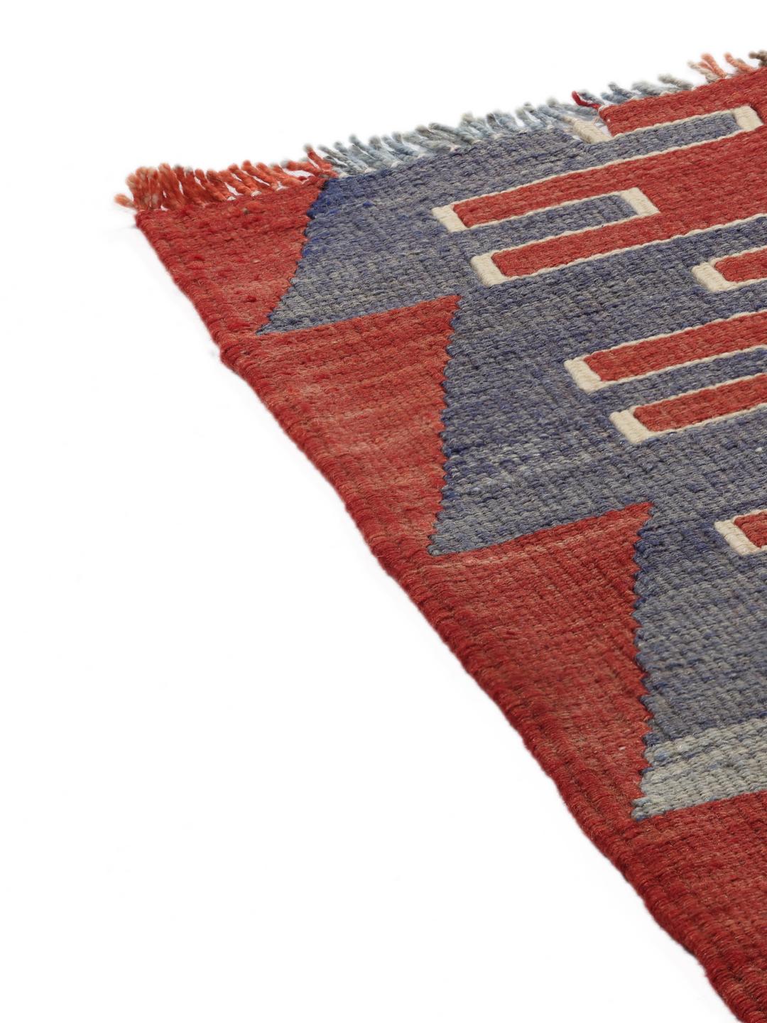 Een kleurrijk vintage Turks Kelim-kleed met geometrische ruitpatronen in rood, groen en blauw.
