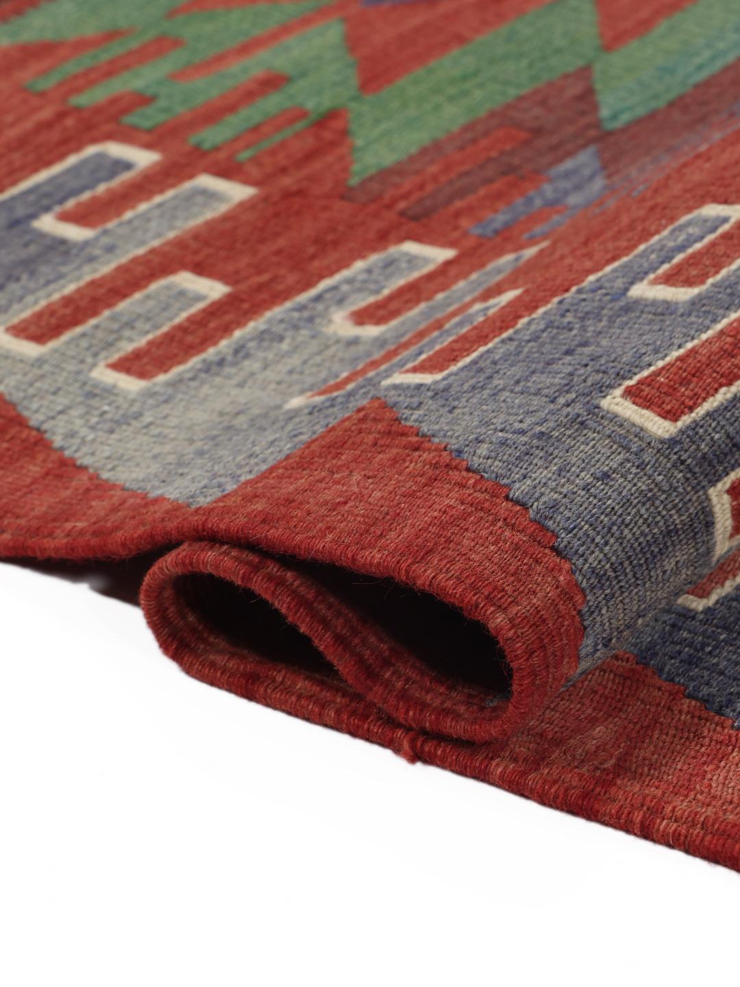 Een kleurrijk vintage Turks Kelim-kleed met geometrische ruitpatronen in rood, groen en blauw.