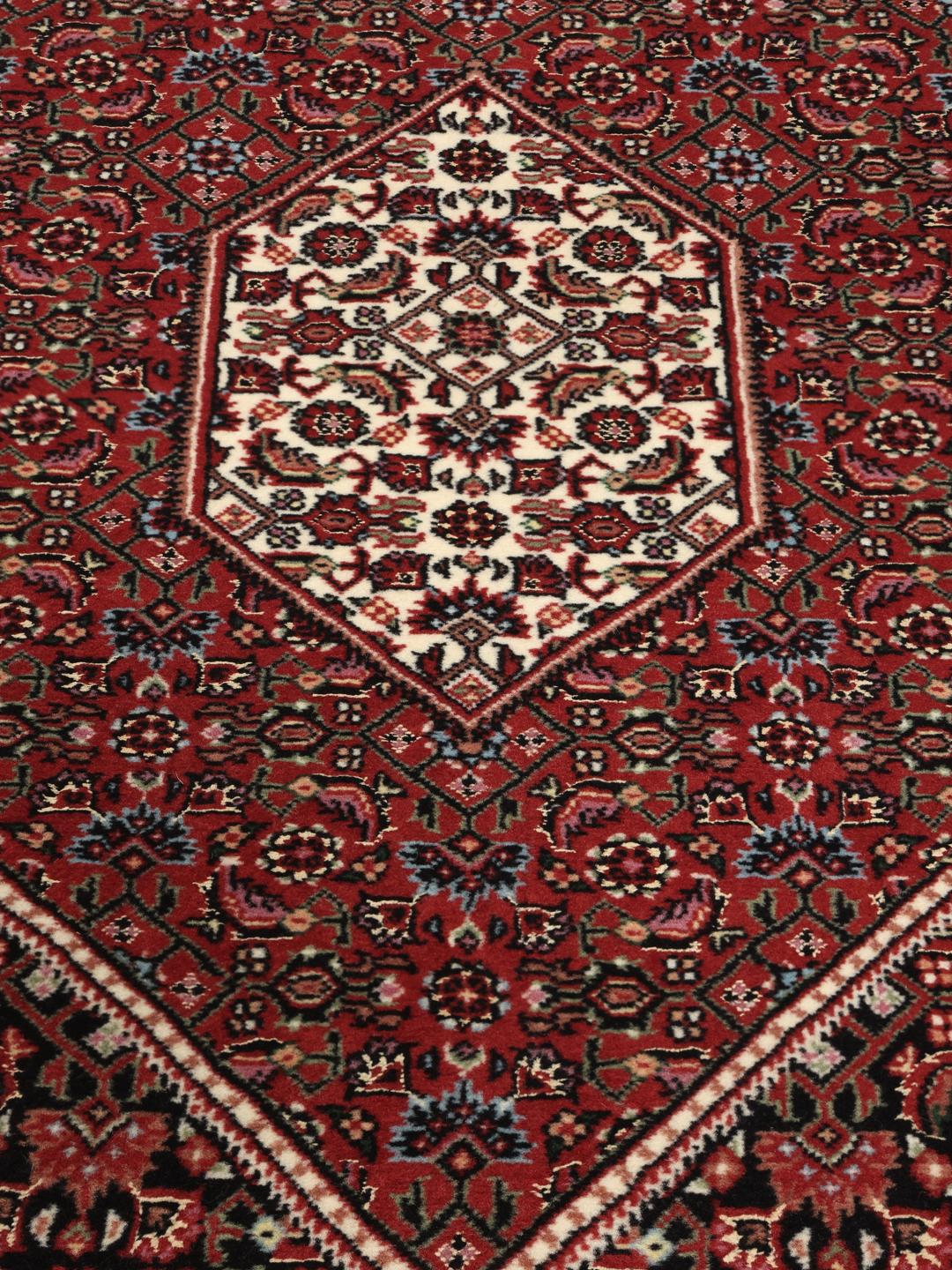 Handgeknoopte Bidjar loper in rood met florale zijden accenten