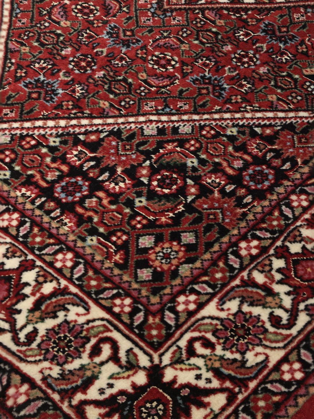 Handgeknoopte Bidjar loper in rood met florale zijden accenten