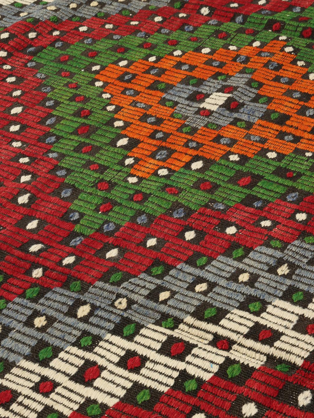Tapis kilim turc tissé à la main avec des motifs géométriques vibrants dans une palette multicolore