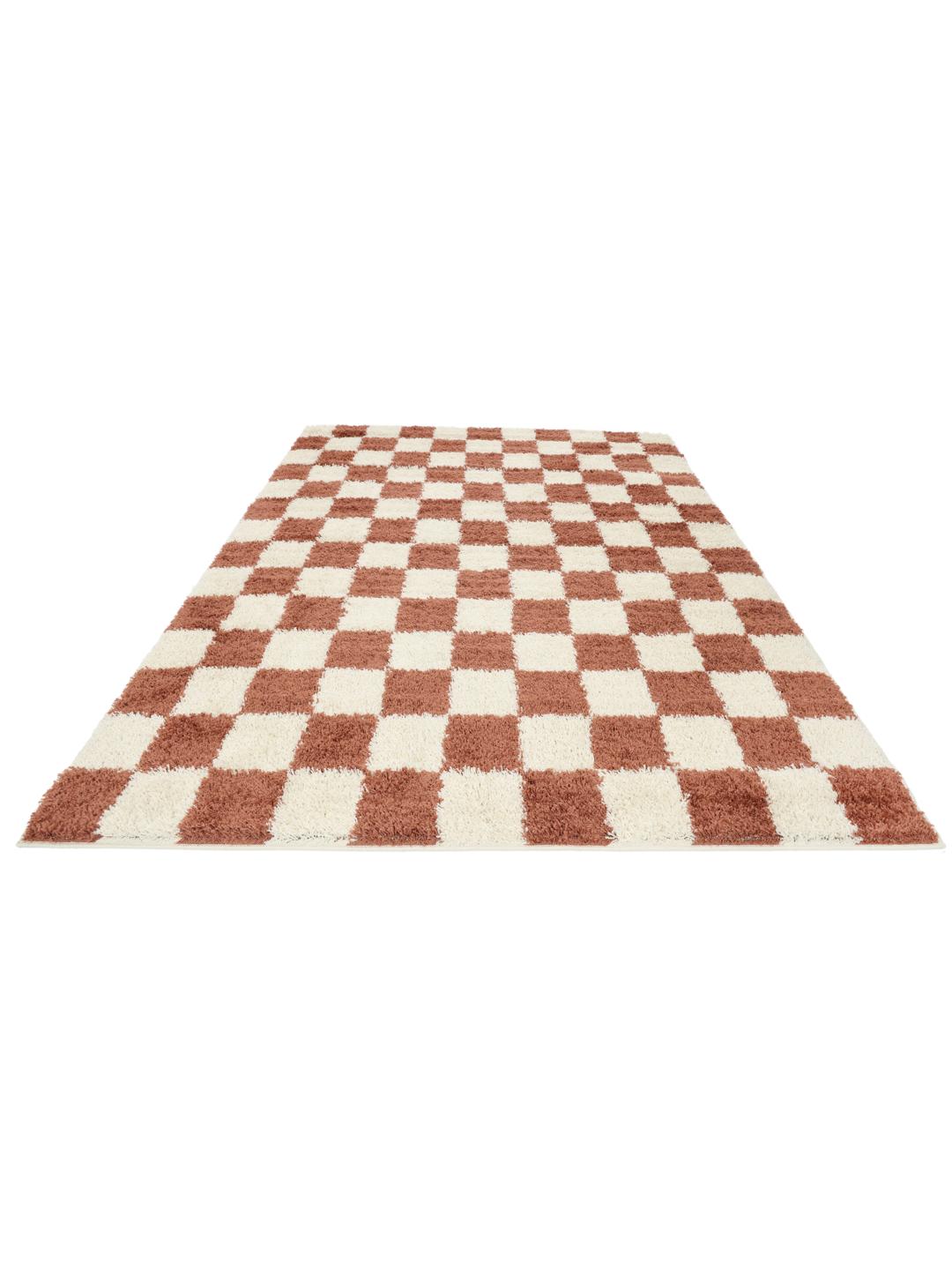 Roestrood en gebroken wit vloerkleed met een pluche geruit patroon.