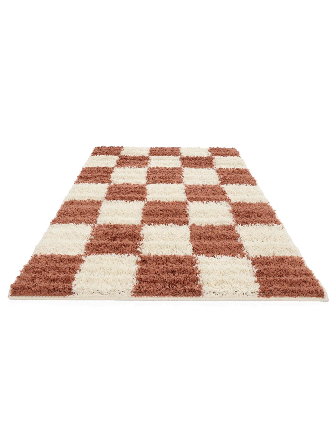 Roestrood en gebroken wit vloerkleed met een pluche geruit patroon.