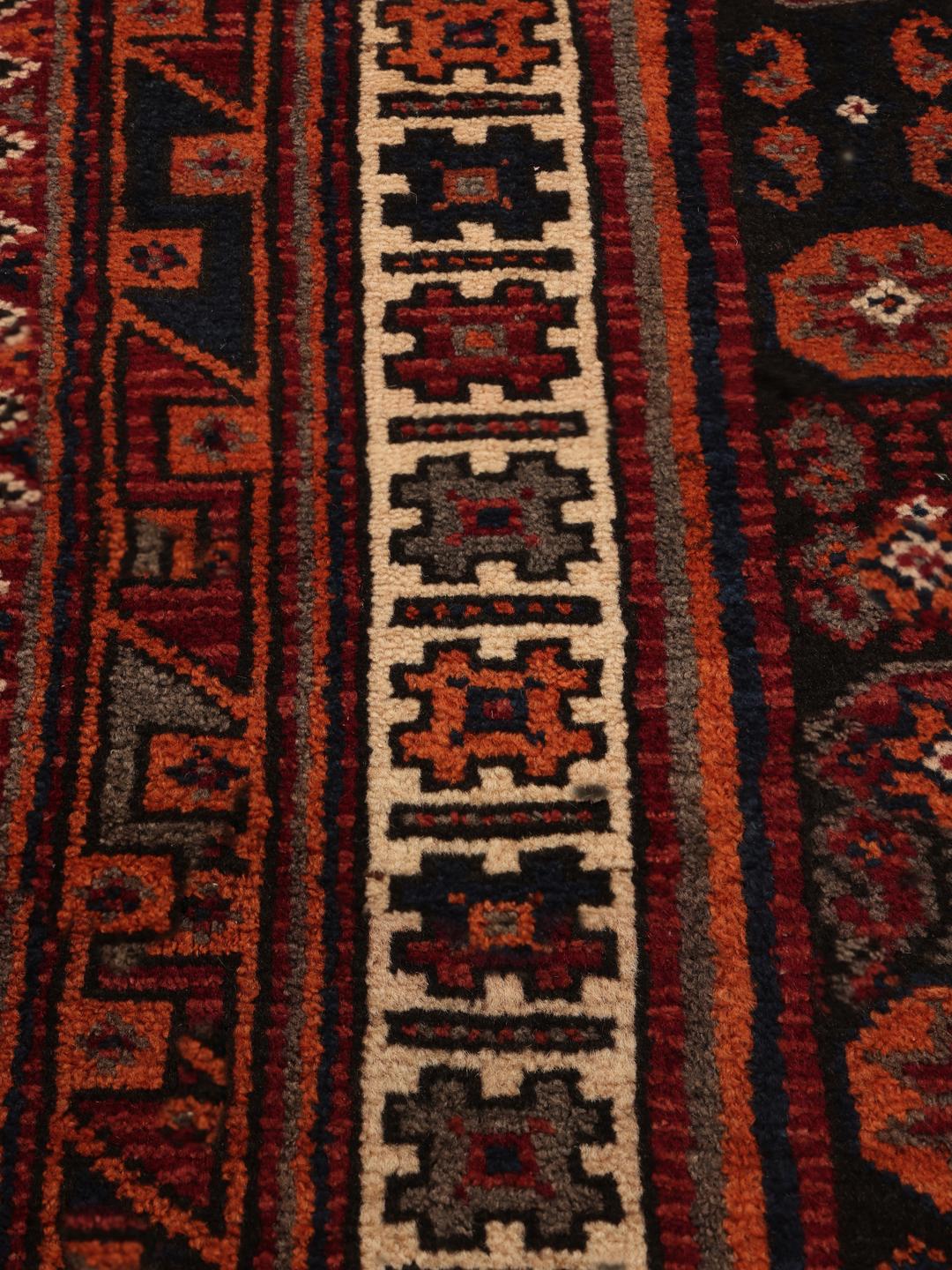Hand-knotted Afshar rug from the Middle East with a red and dark-red geometric design