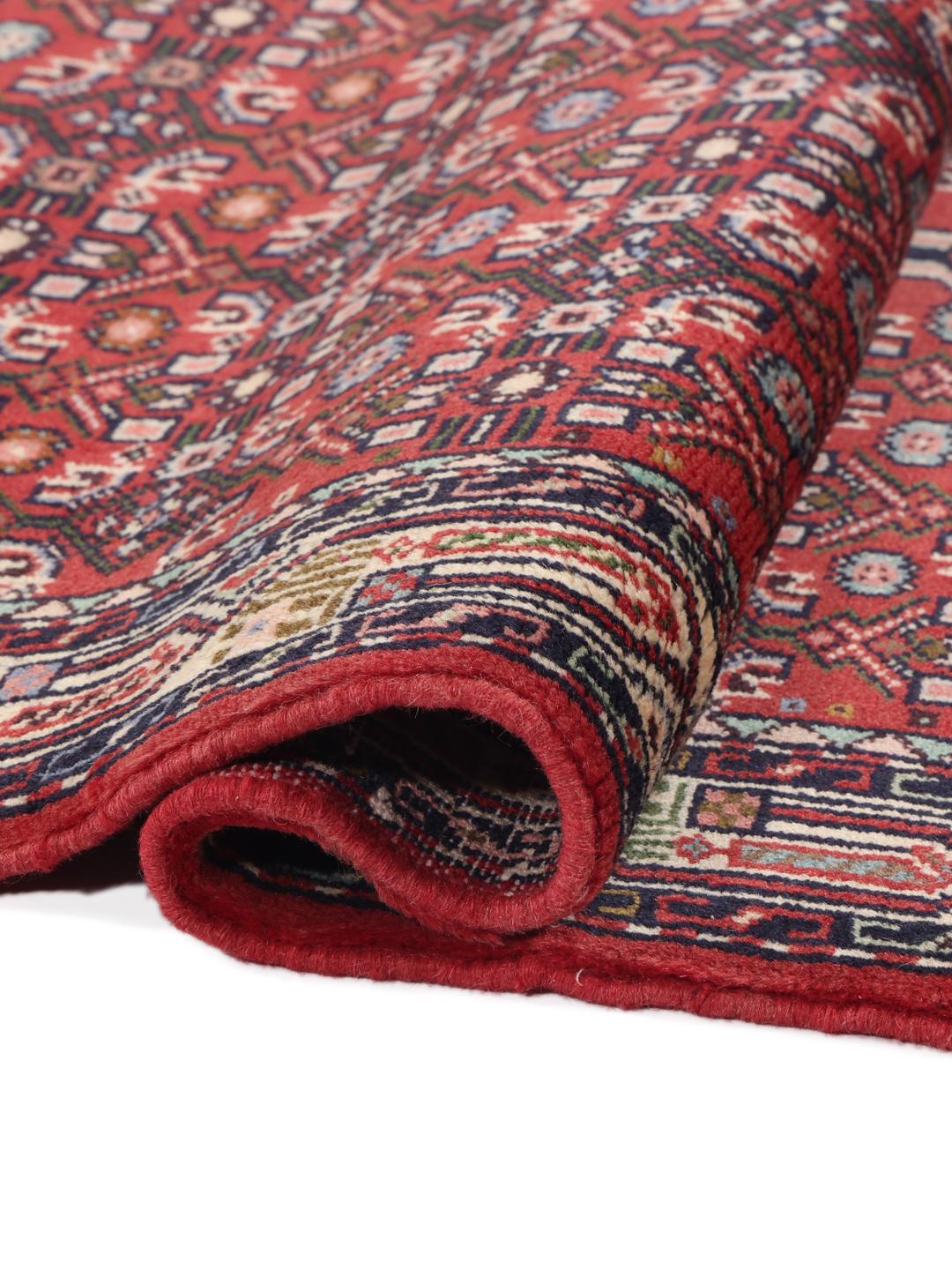 A hand-knotted Hamadan rug from the Middle East featuring a vibrant red and dark blue geometric pattern.