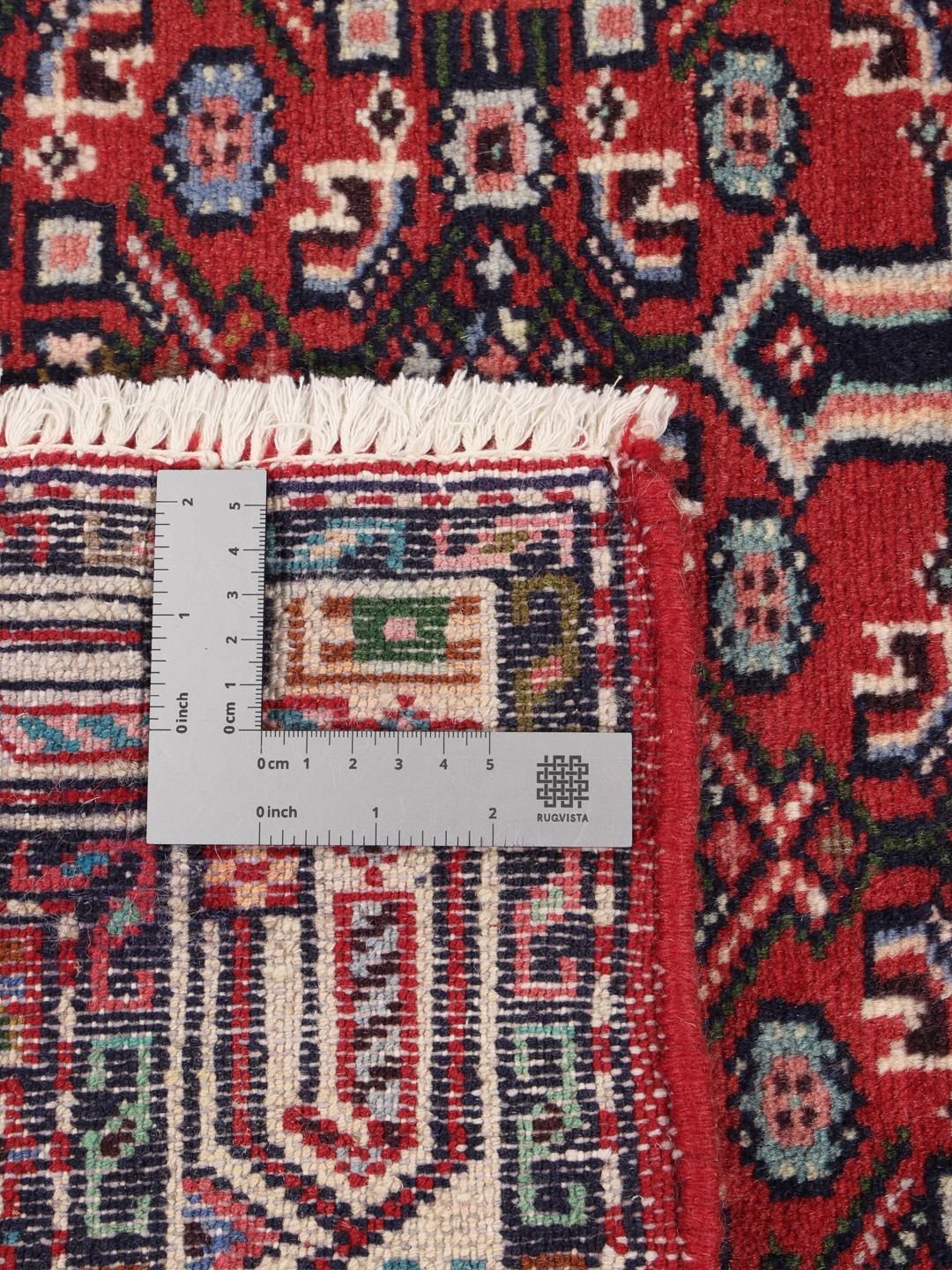 A hand-knotted Hamadan rug from the Middle East featuring a vibrant red and dark blue geometric pattern.