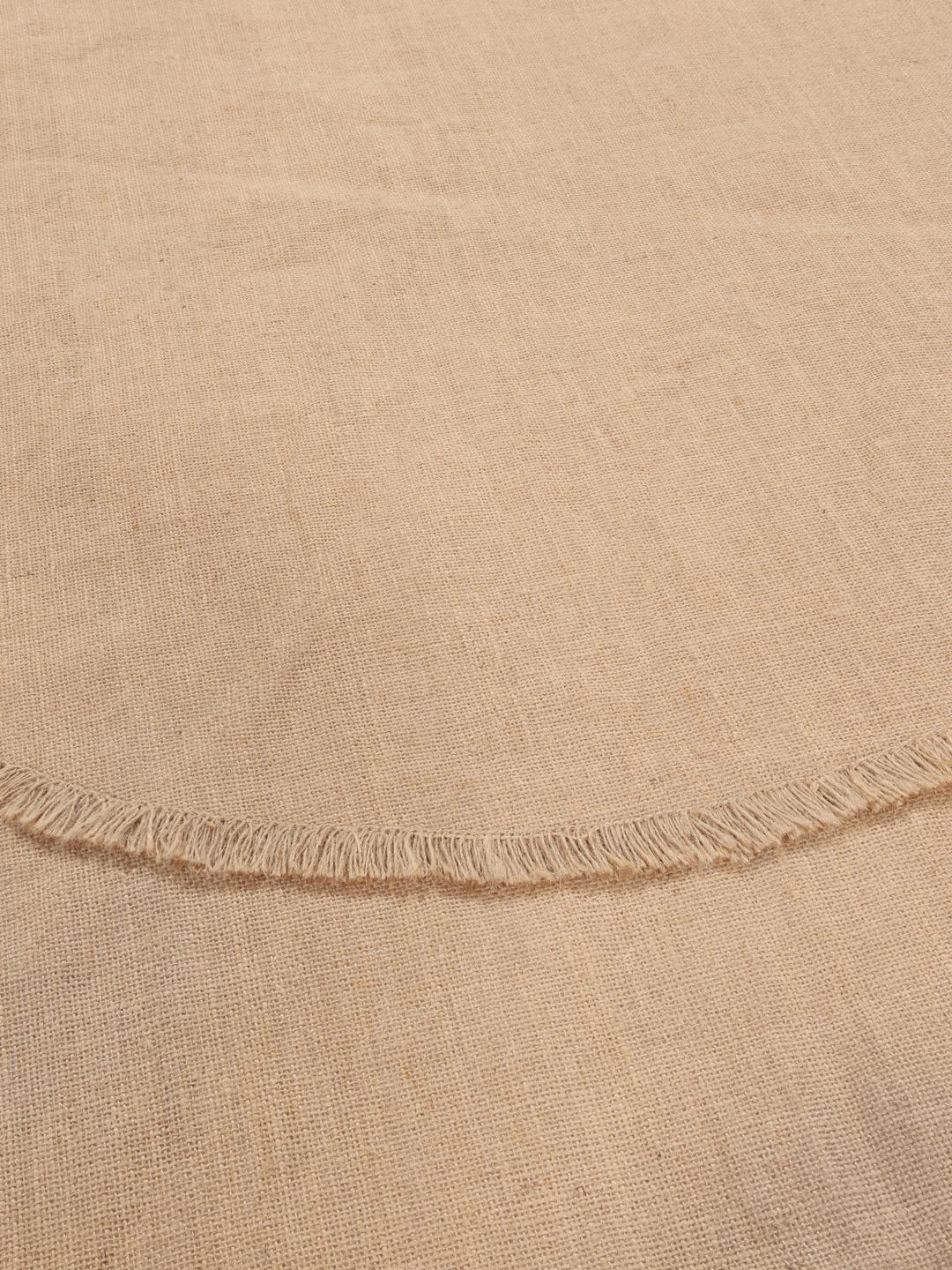 Rundt beige vævet tæppe med frynsedetaljer