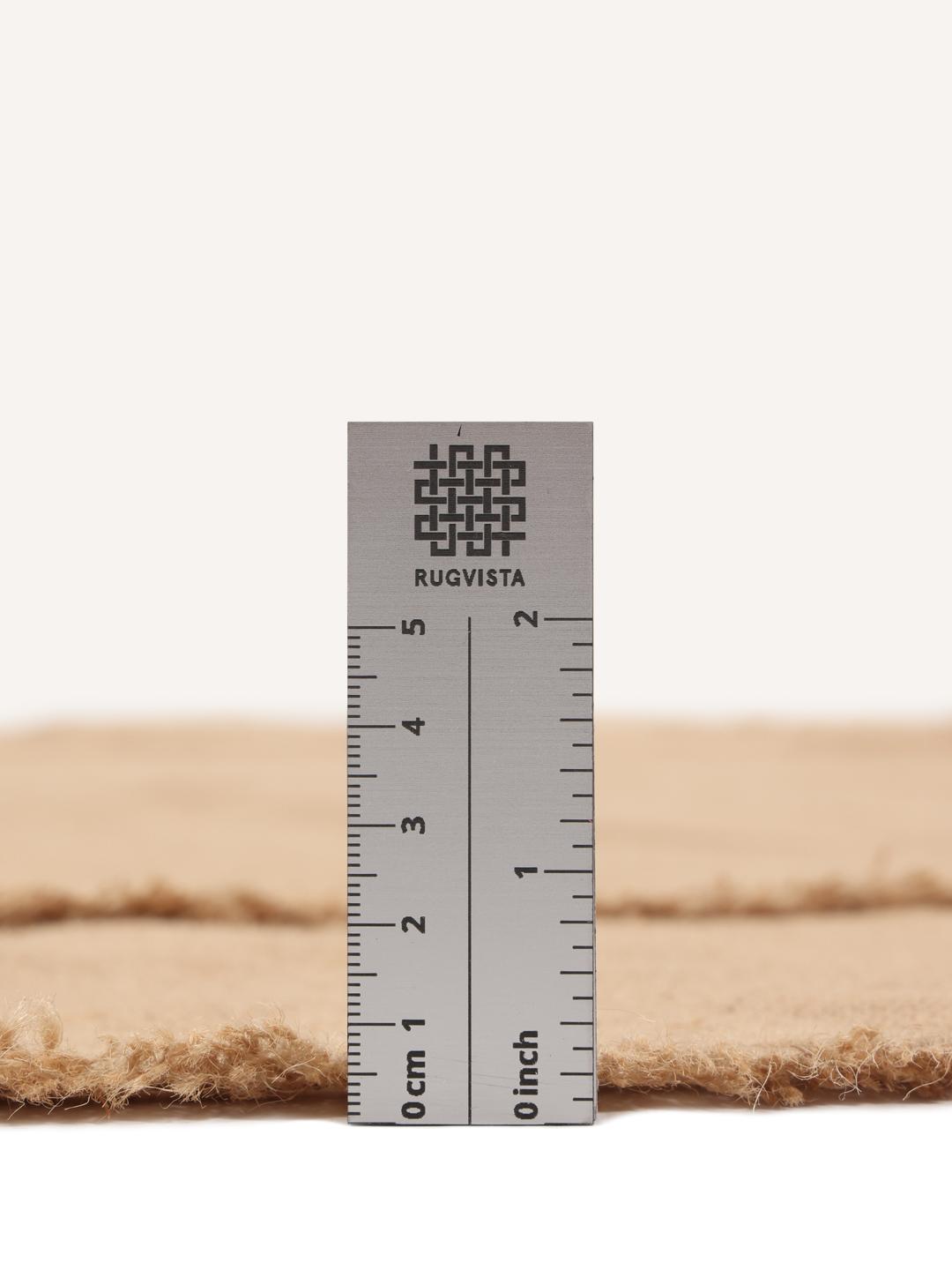 Rundt beige vævet tæppe med frynsedetaljer
