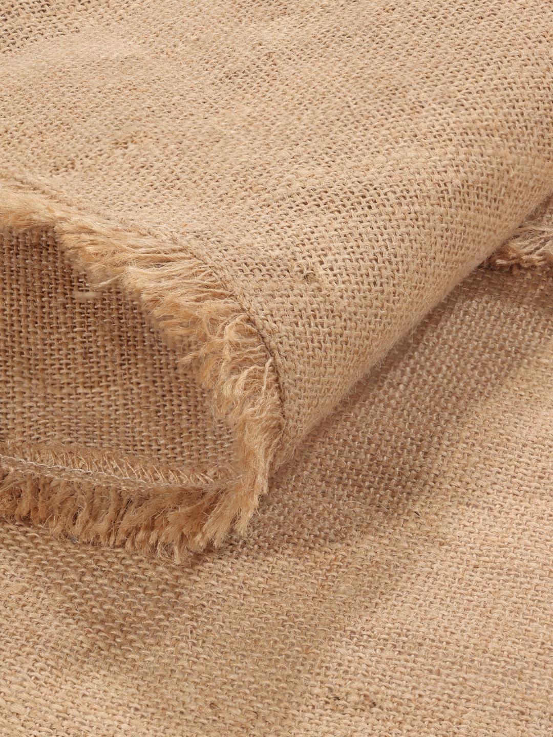 Rundt beige vævet tæppe med frynsedetaljer