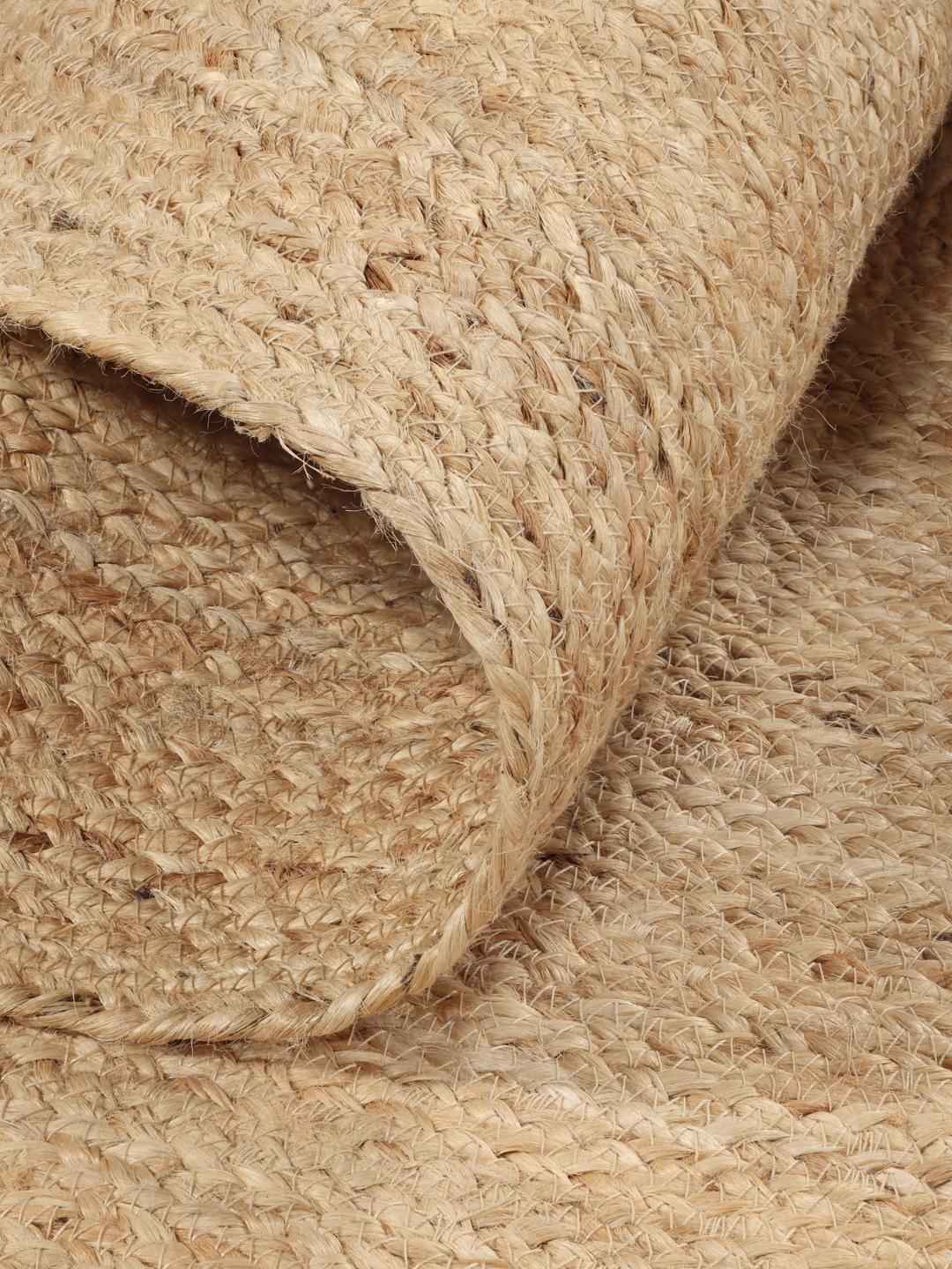 Rundt beige tæppe lavet af naturlig jute