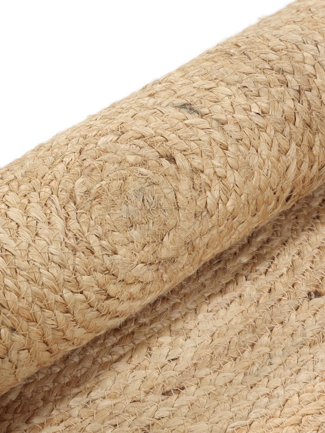 Rundt beige tæppe lavet af naturlig jute