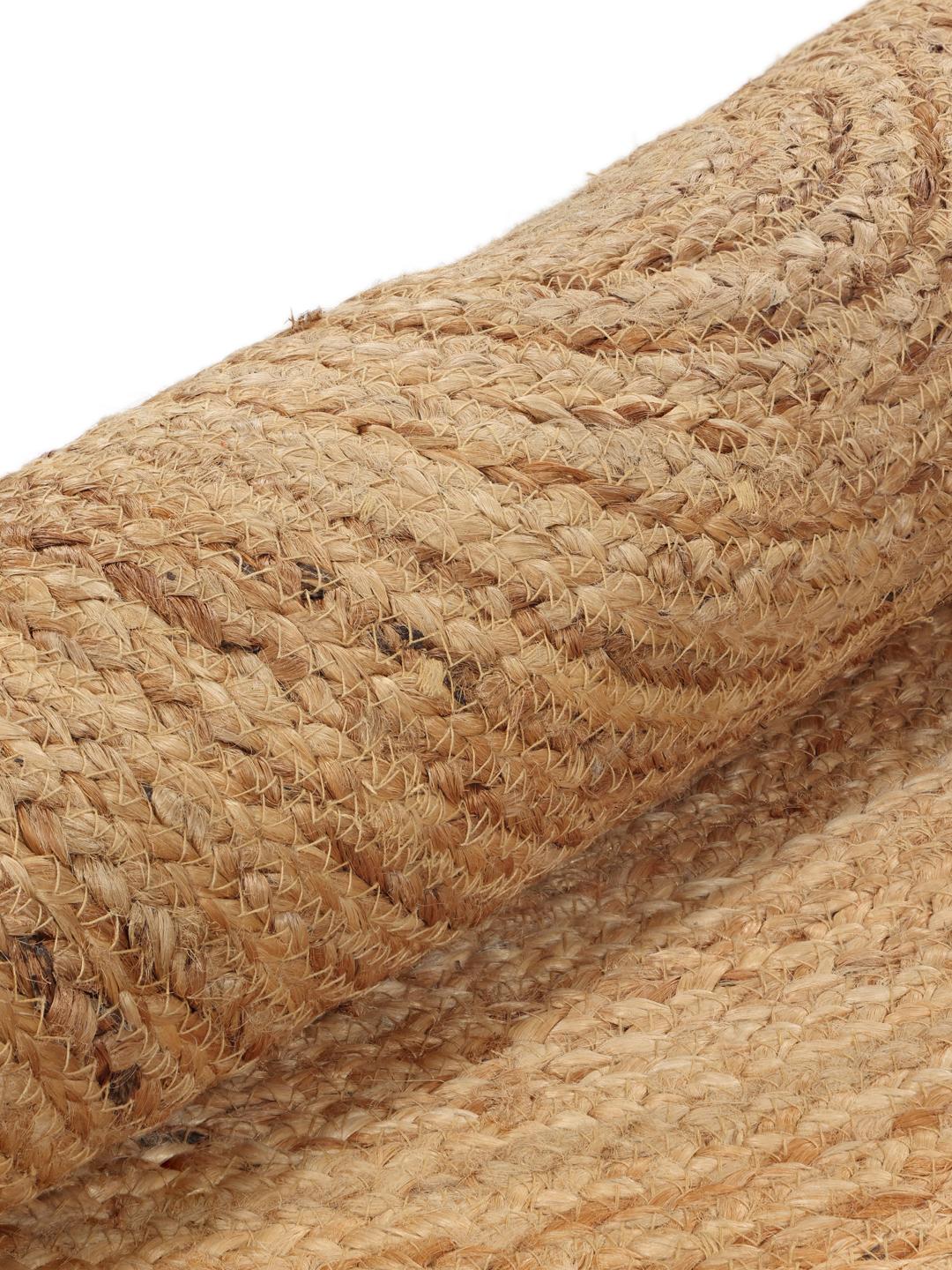 Een bloemvormig beige jute vloerkleed met een zwarte rand.