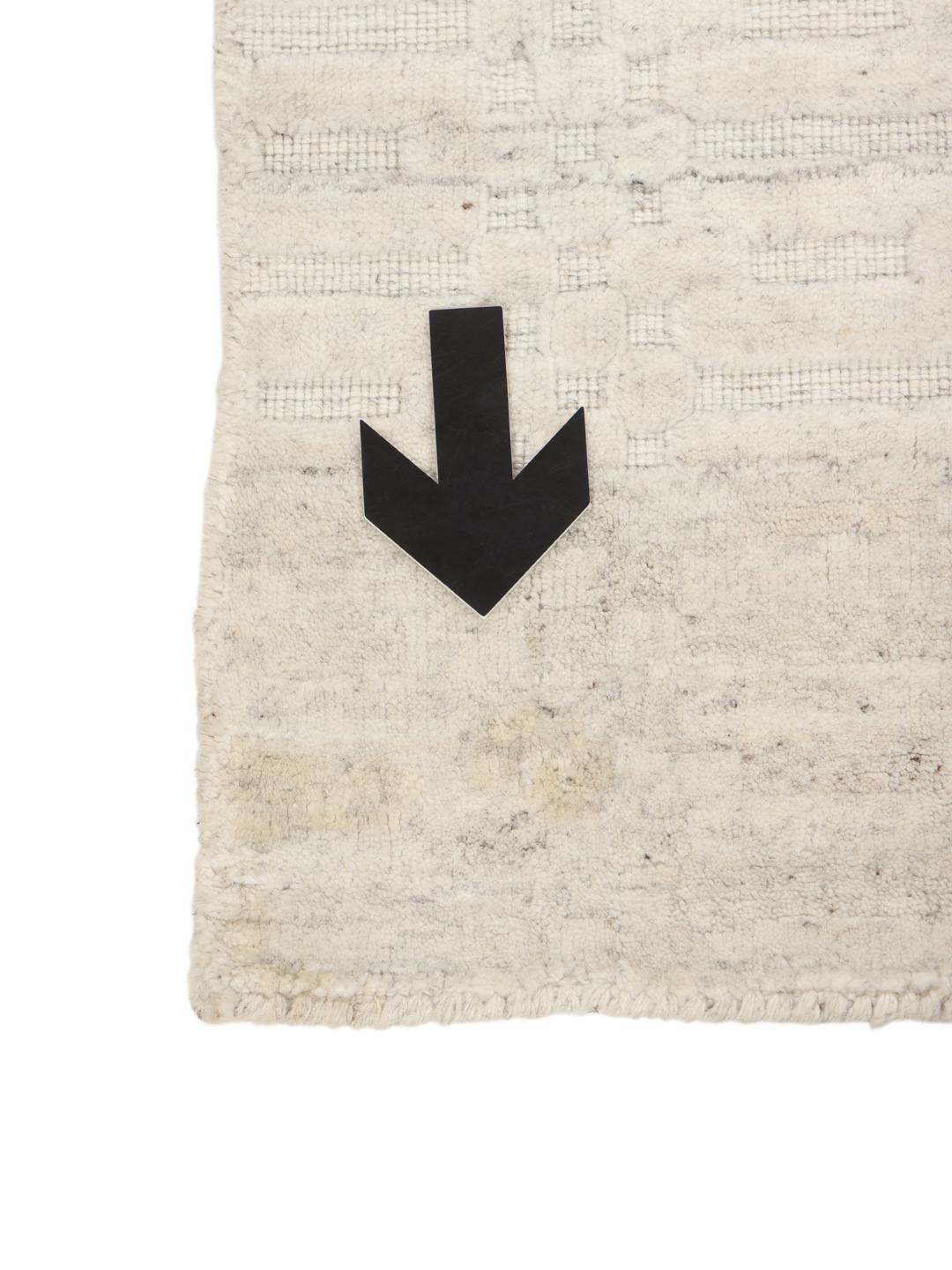 Beige tapijt met subtiel textuurpatroon en minimalistisch design