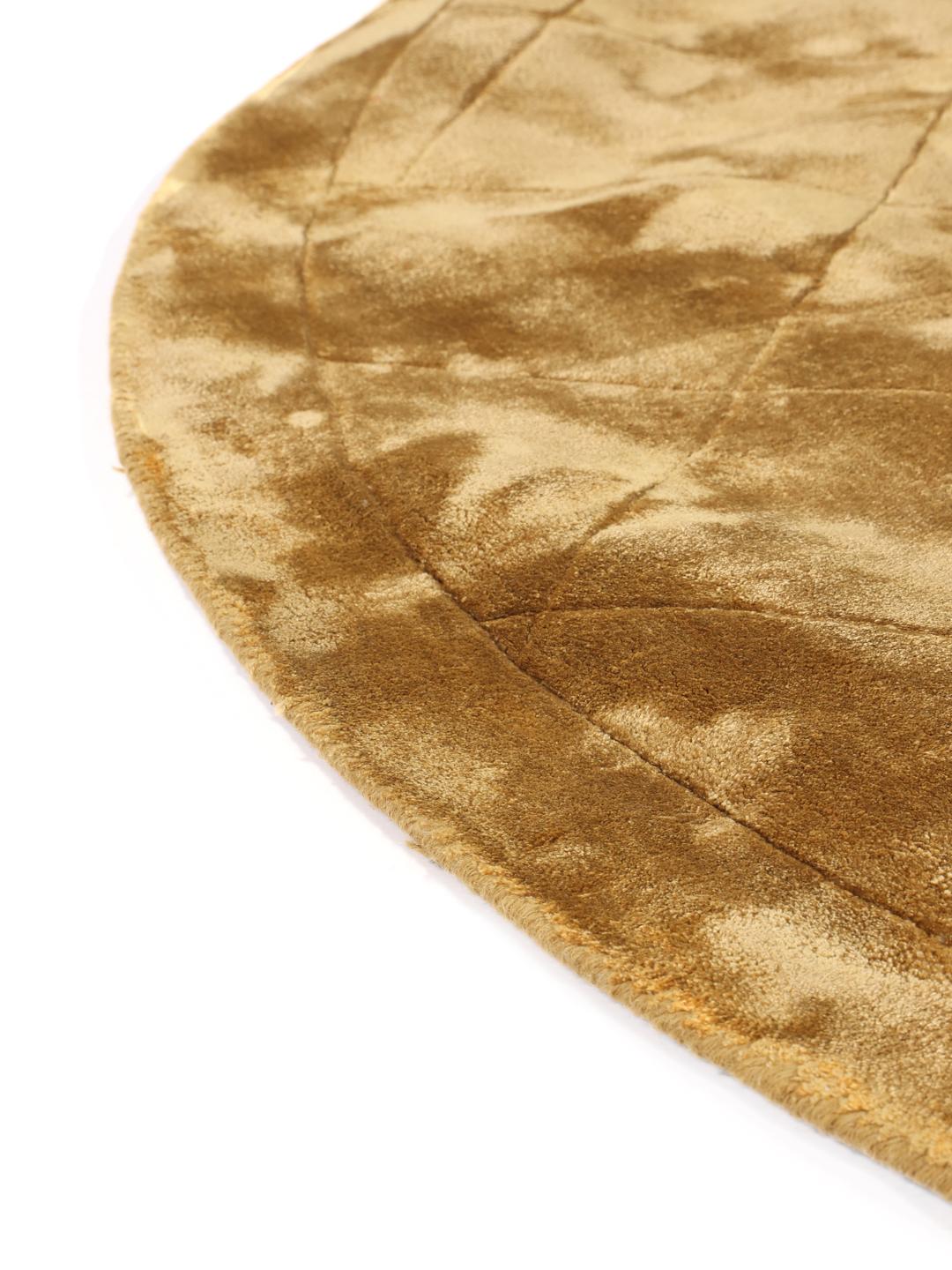 Rond goudkleurig vloerkleed met een diamantvormig quiltpatroon