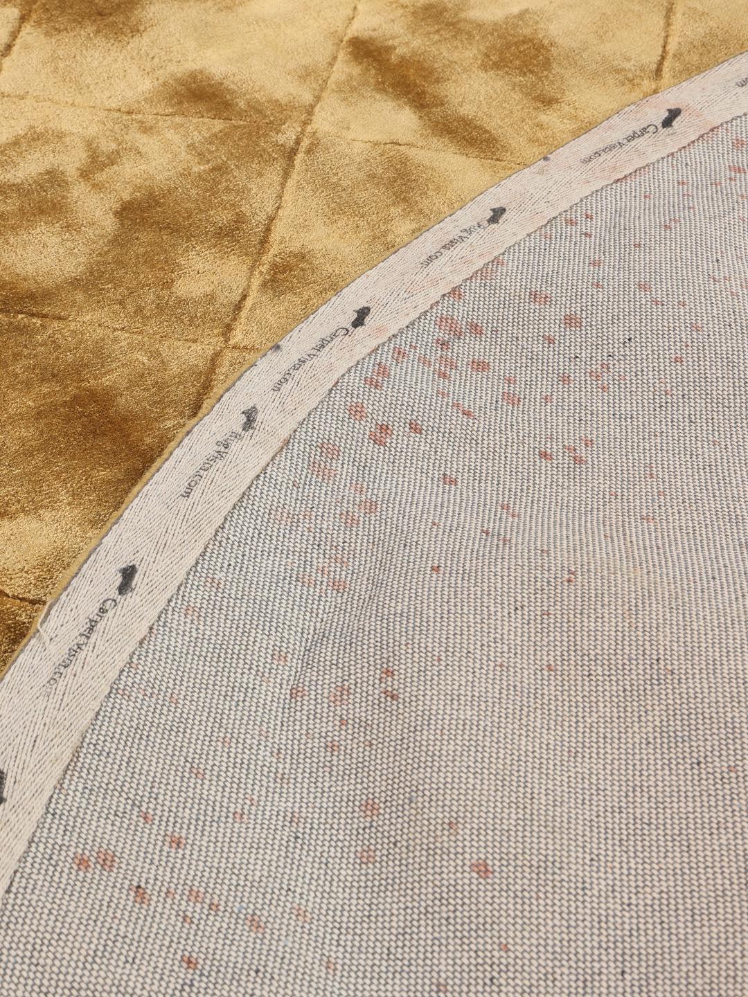 Rond goudkleurig vloerkleed met een diamantvormig quiltpatroon