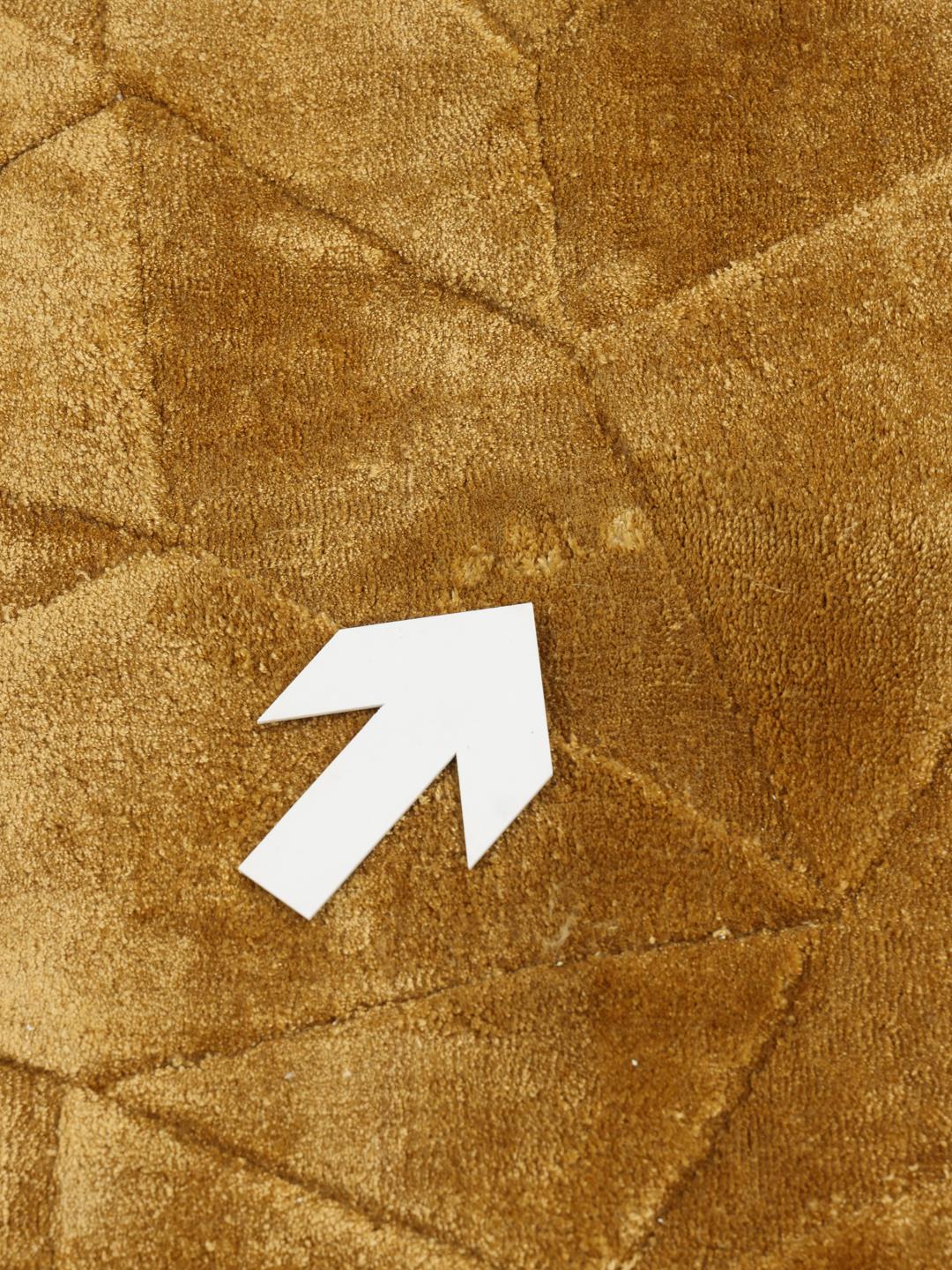 Een modern geel vloerkleed met een verfijnd geometrisch patroon.