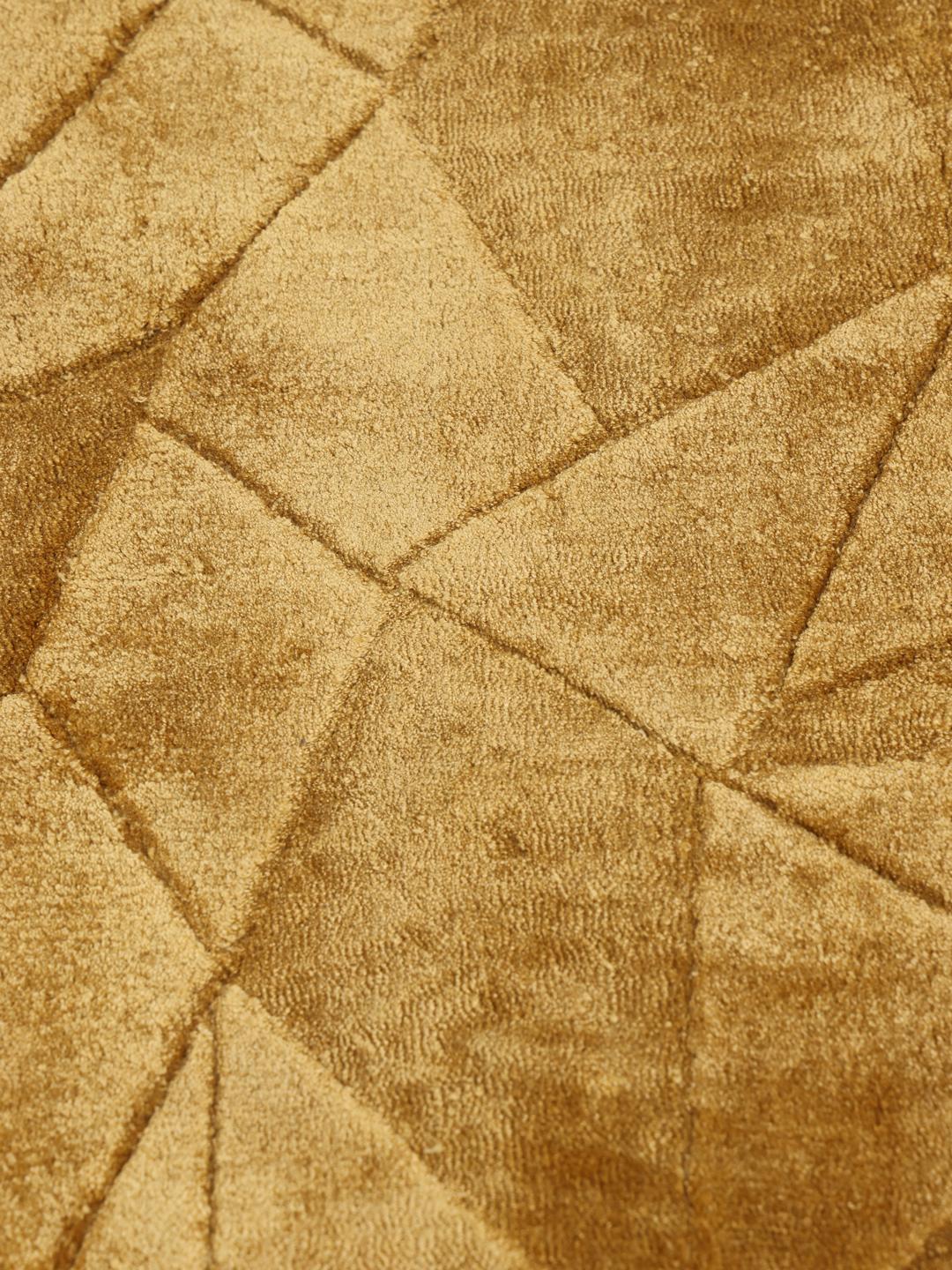 Een modern geel vloerkleed met een verfijnd geometrisch patroon.