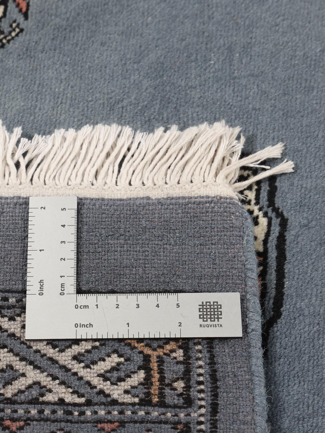 Handgeknoopt Pakistan Bokhara kleed met een blauw veld en herhalende motieven