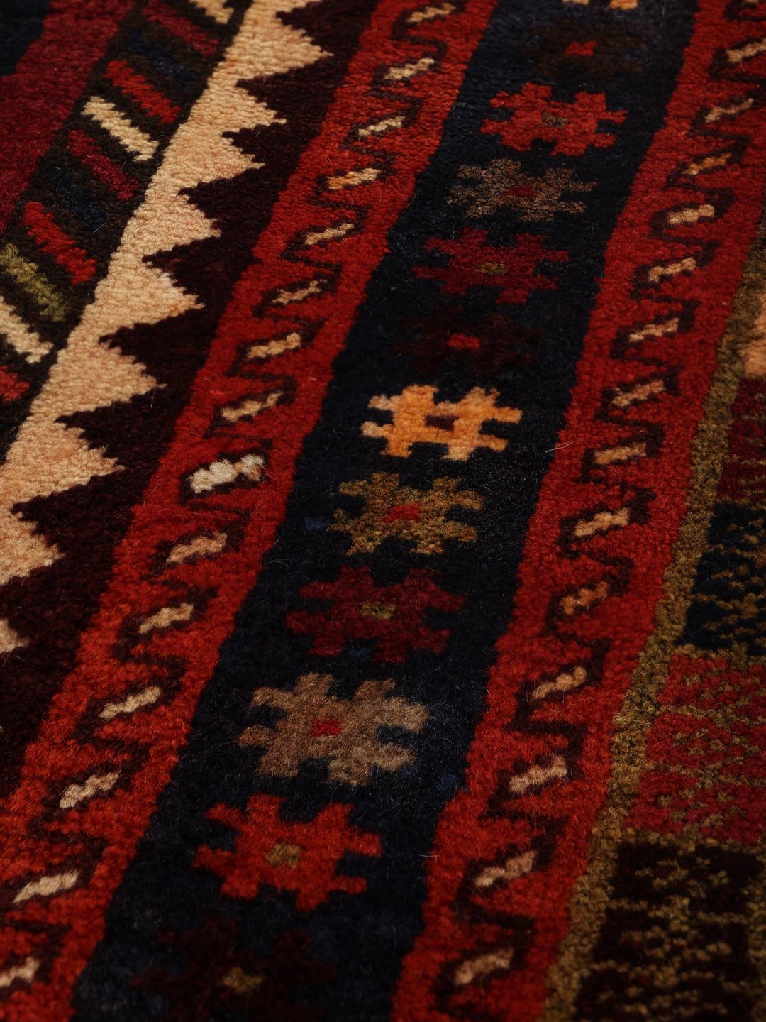 Handgeknoopt tapijt uit het Midden-Oosten in donkerrood met traditionele geometrische motieven
