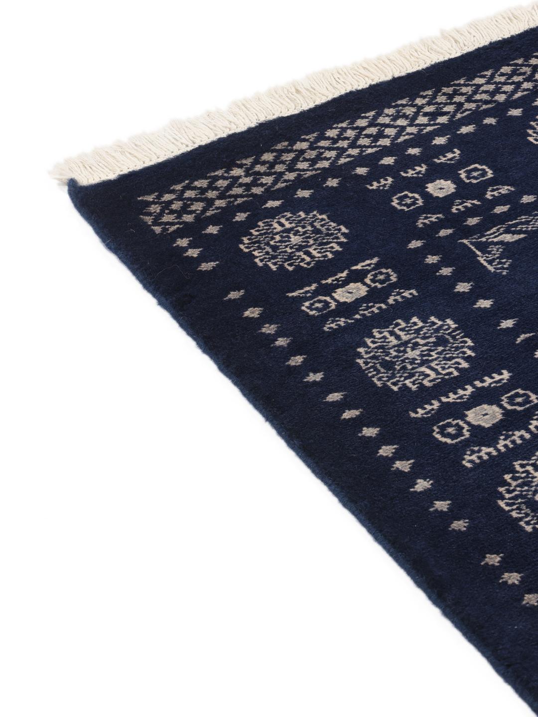 Hand-knotted wool rug from Pakistan in dark-blue with light-coloured geometric motifs.