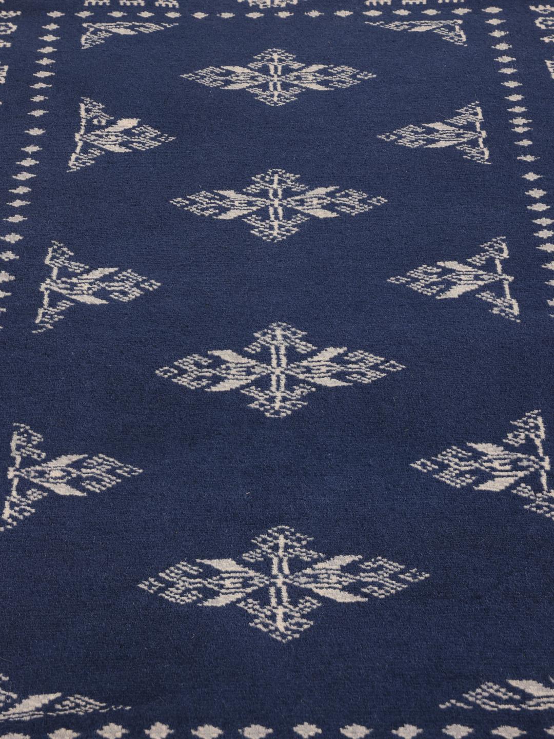 Hand-knotted wool rug from Pakistan in dark-blue with light-coloured geometric motifs.