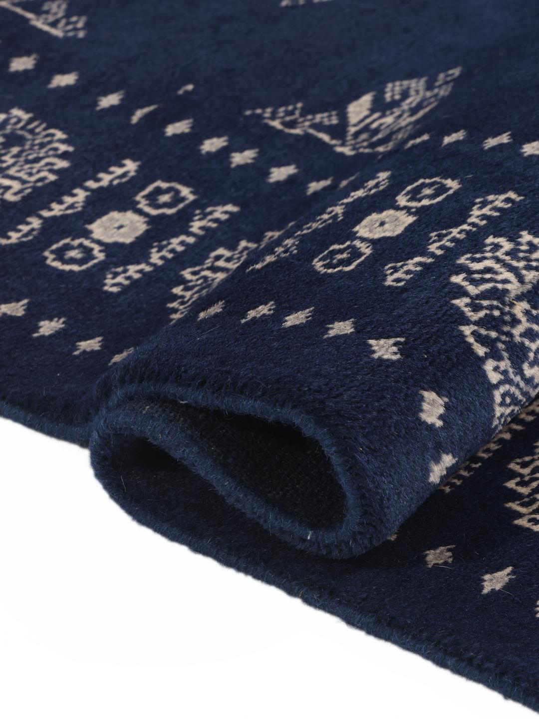 Hand-knotted wool rug from Pakistan in dark-blue with light-coloured geometric motifs.