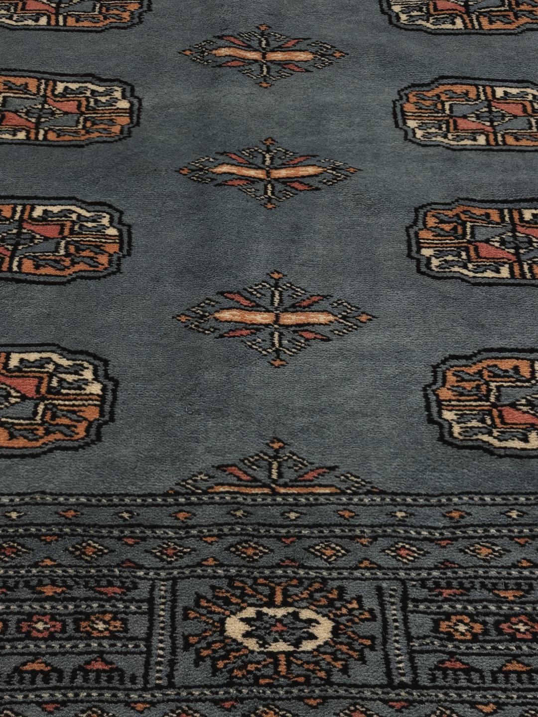 Hand-knotted Pakistan Bokhara rug in a serene blue with traditional motifs