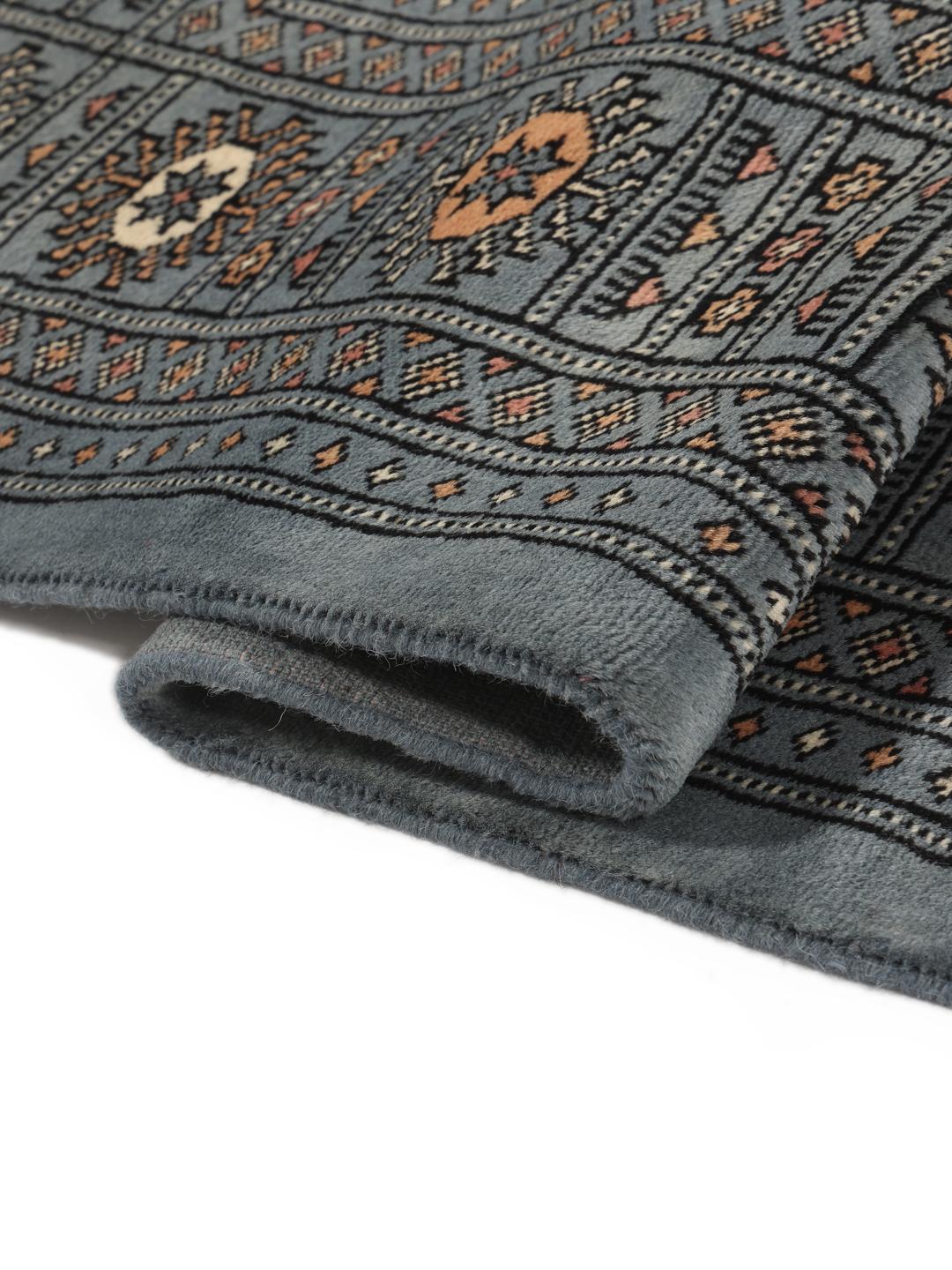 Hand-knotted Pakistan Bokhara rug in a serene blue with traditional motifs