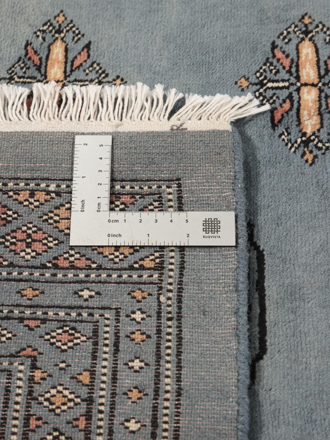 Hand-knotted Pakistan Bokhara rug in a serene blue with traditional motifs