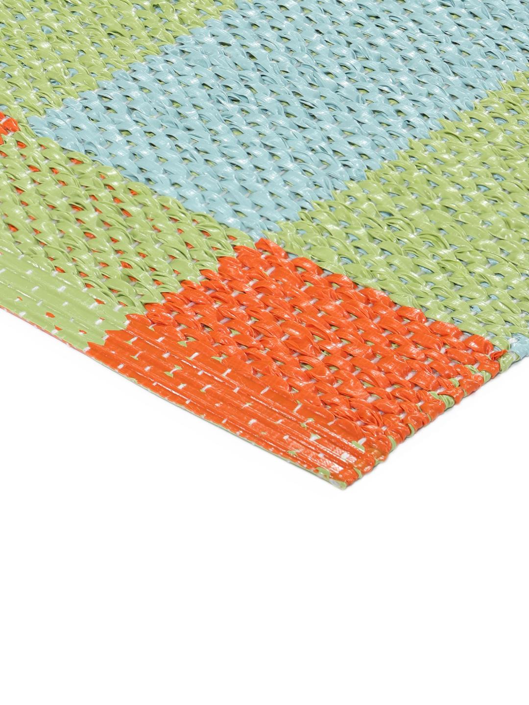 Un tapis rectangulaire présentant un motif à carreaux vibrant orange bleu et vert clair.