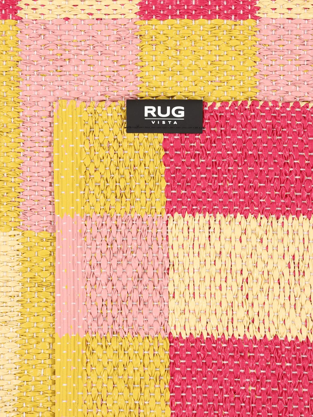 Tapis rectangulaire rose et jaune avec un motif à blocs