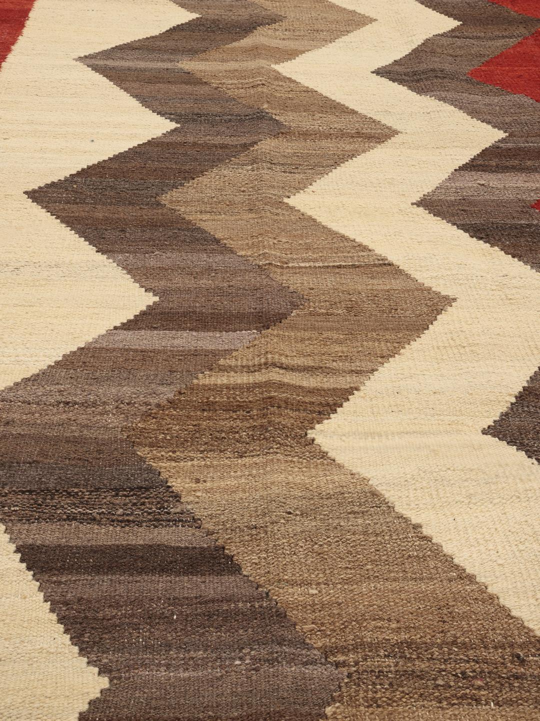 Handgeweven Afghaans Kilim-tapijt met een rood en bruin zigzagpatroon op een crèmekleurige achtergrond