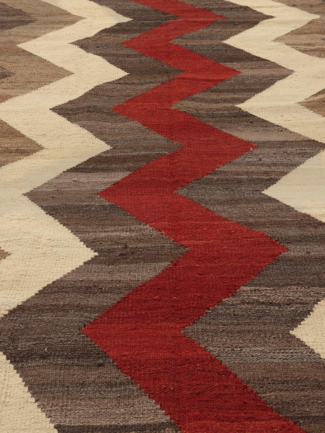 Handgeweven Afghaans Kilim-tapijt met een rood en bruin zigzagpatroon op een crèmekleurige achtergrond