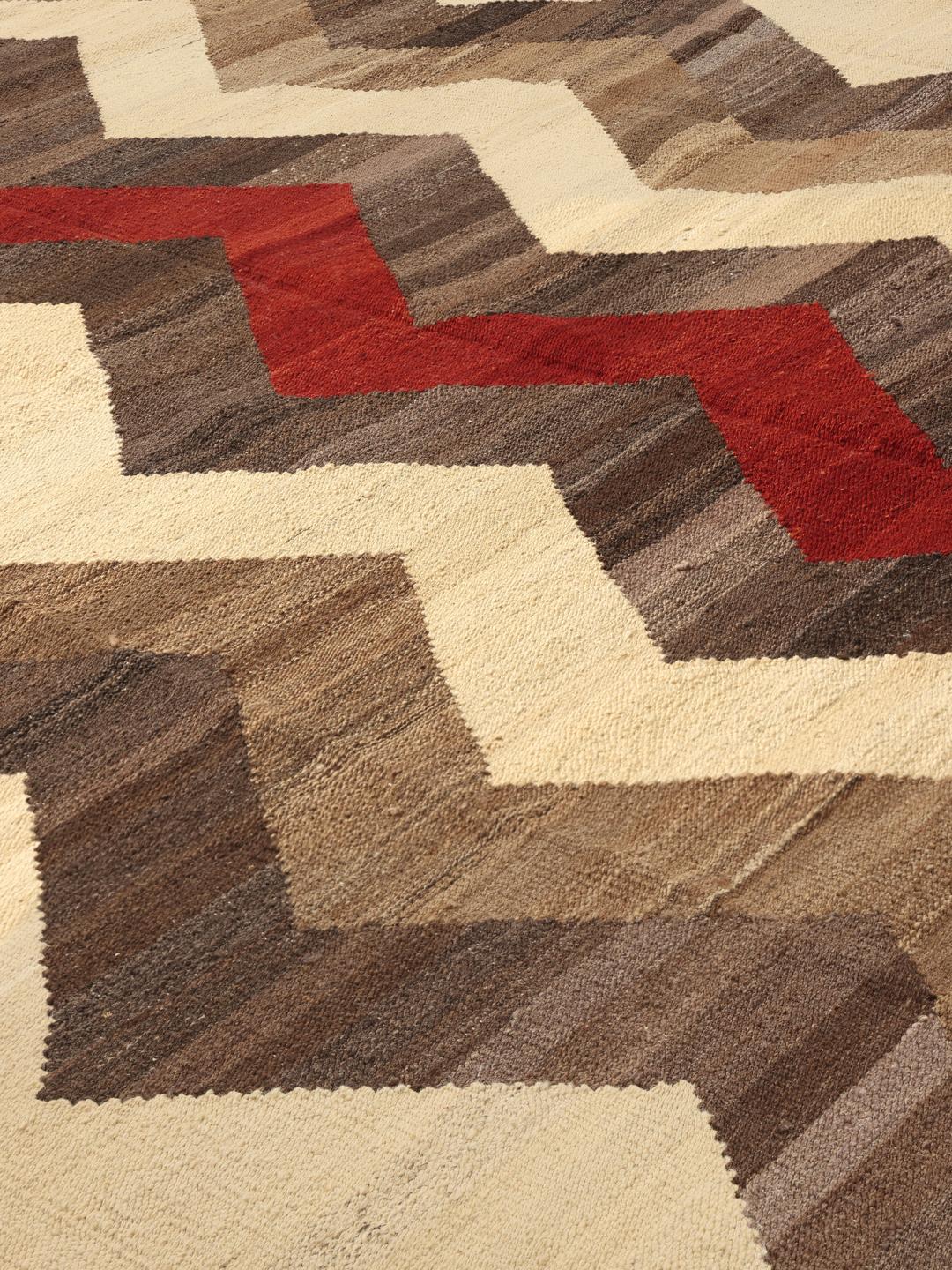 Handgeweven Afghaans Kilim-tapijt met een rood en bruin zigzagpatroon op een crèmekleurige achtergrond