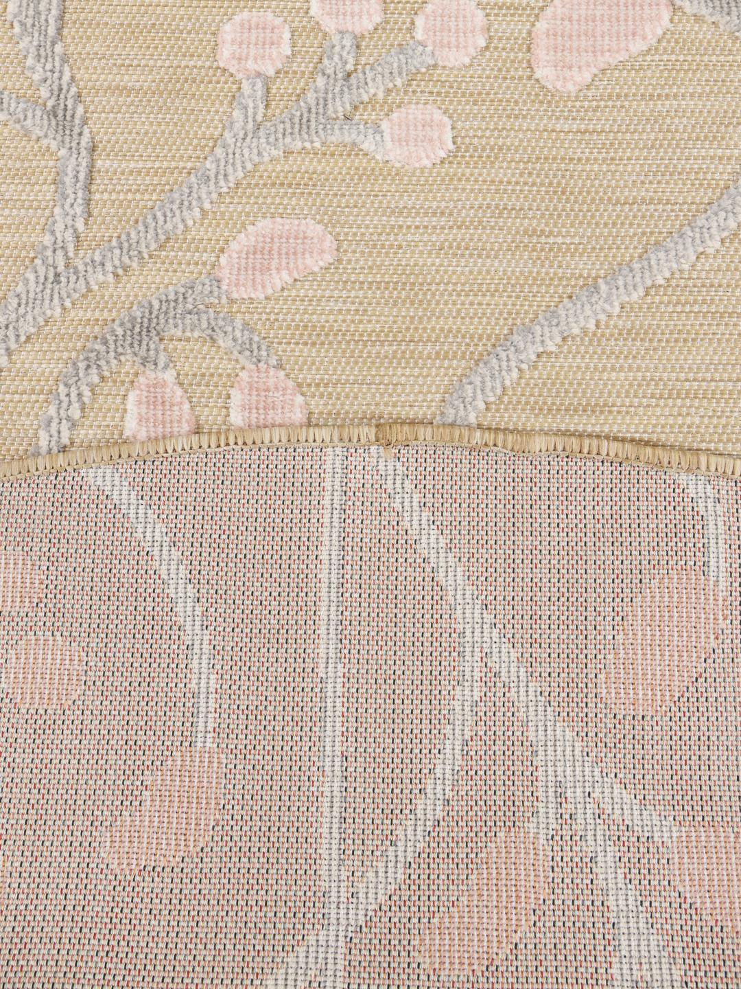 Beige round rug with pink floral motifs