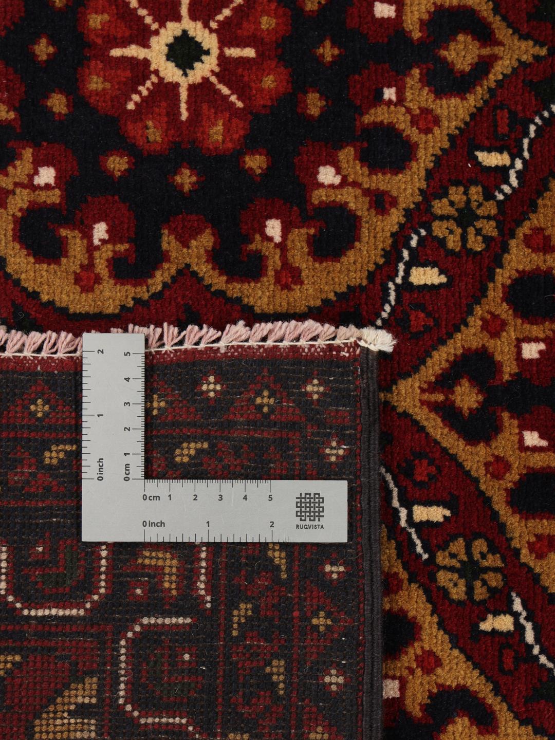 Håndknyttet Kunduz-tæppe fra Afghanistan i mørkerøde og mørkeblå toner.