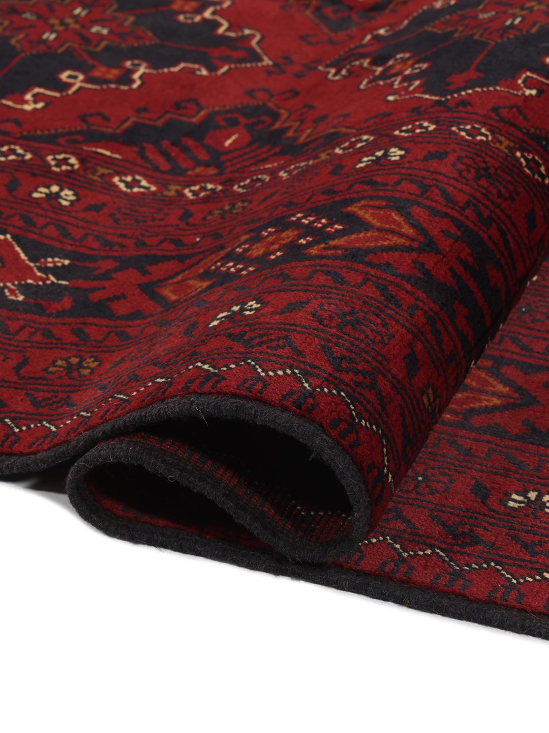A hand-knotted Kunduz rug from Afghanistan with a dark-red field and geometric patterns.