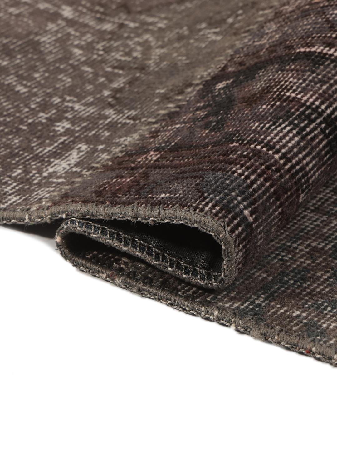 Et rektangulært patchwork-teppe fra Tyrkia i mørkegrå og svarte toner.
