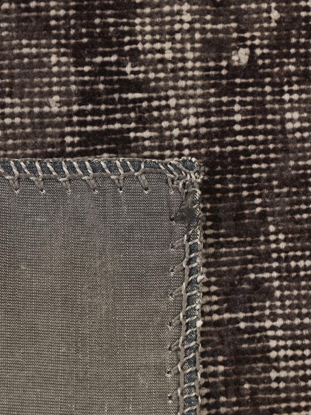 Et rektangulært patchwork-teppe fra Tyrkia i mørkegrå og svarte toner.