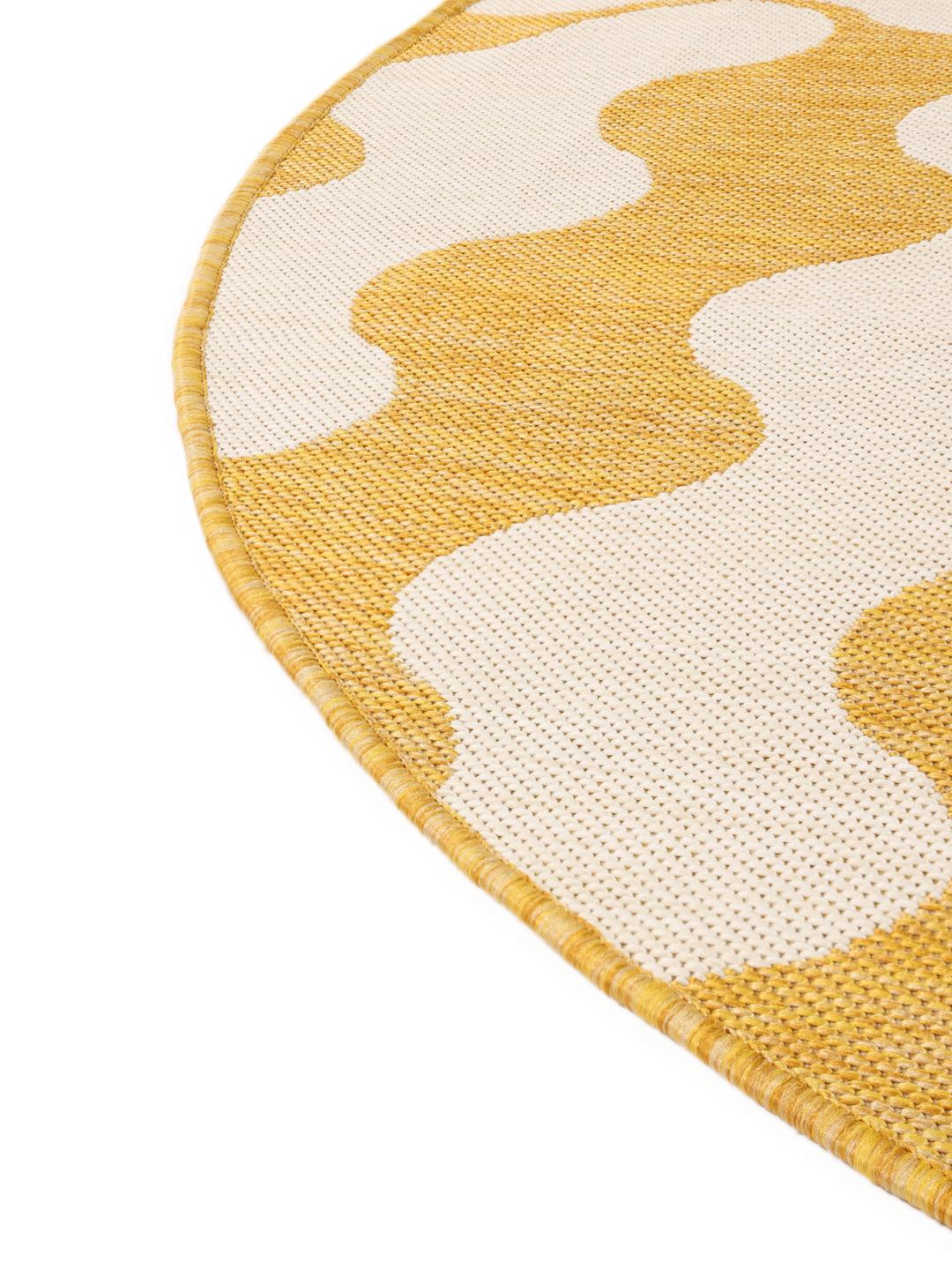 Un tapis rond jaune et blanc avec un motif ondulé