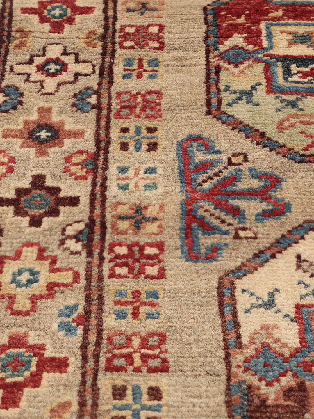 Covor Kazak înnodat manual din Afganistan în nuanțe de bej cu motive colorate complexe.