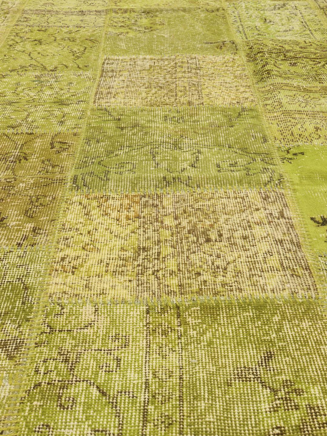Et stort rektangulært patchwork-tæppe fra Mellemøsten i grønne nuancer.